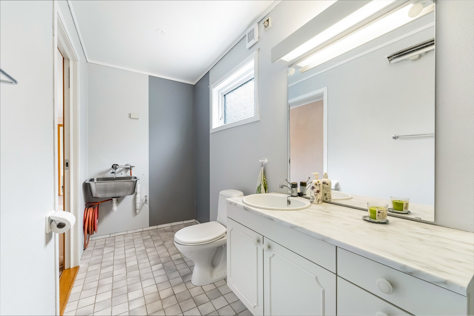 Badet er et kombinert bad og vaskerom. Vaskeromsdelen er naturlig adskilt med utslagsvask og opplegg til vaskemaskin. Galleribilde