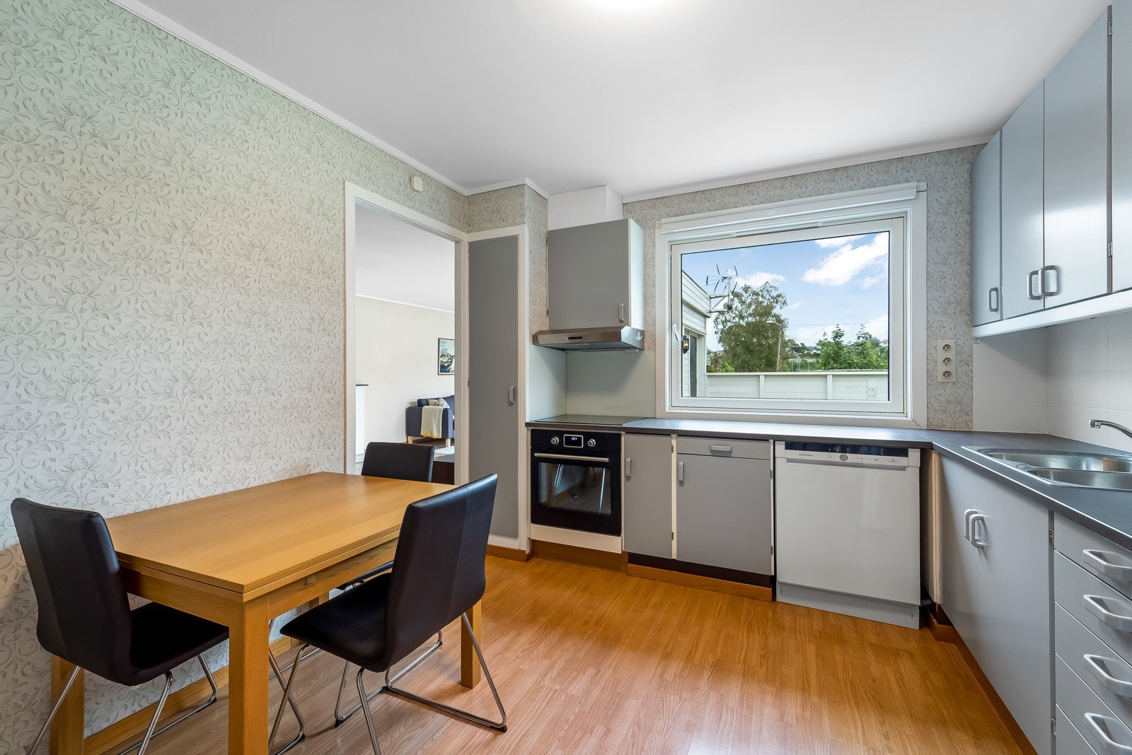 Pent oppmalt kjøkken med eldre innredning. Avsatt plass til hvitevarer. Galleribilde