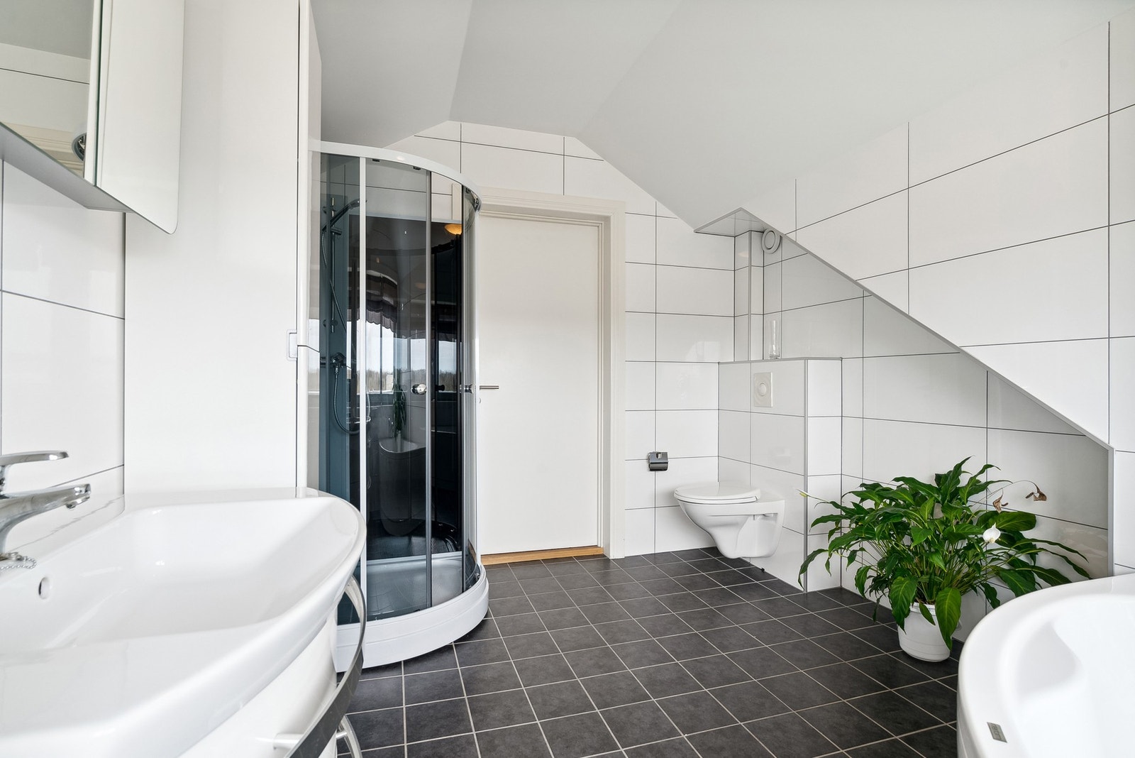 Vegghengt toalett og flislagt gulv med varmekabler Galleribilde