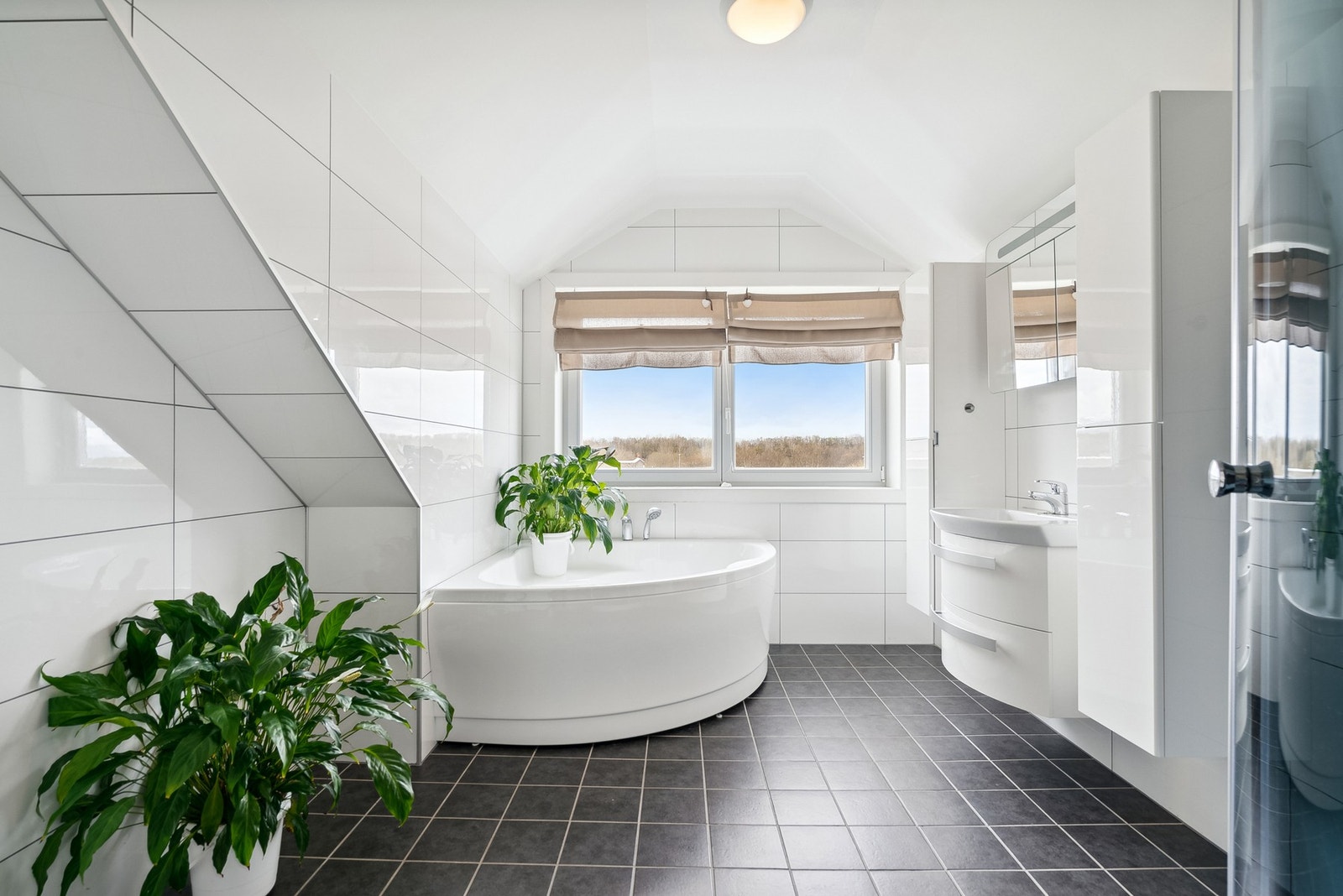 Boligen har et moderne og innbydende baderom med både dusjkabinett og badekar Galleribilde