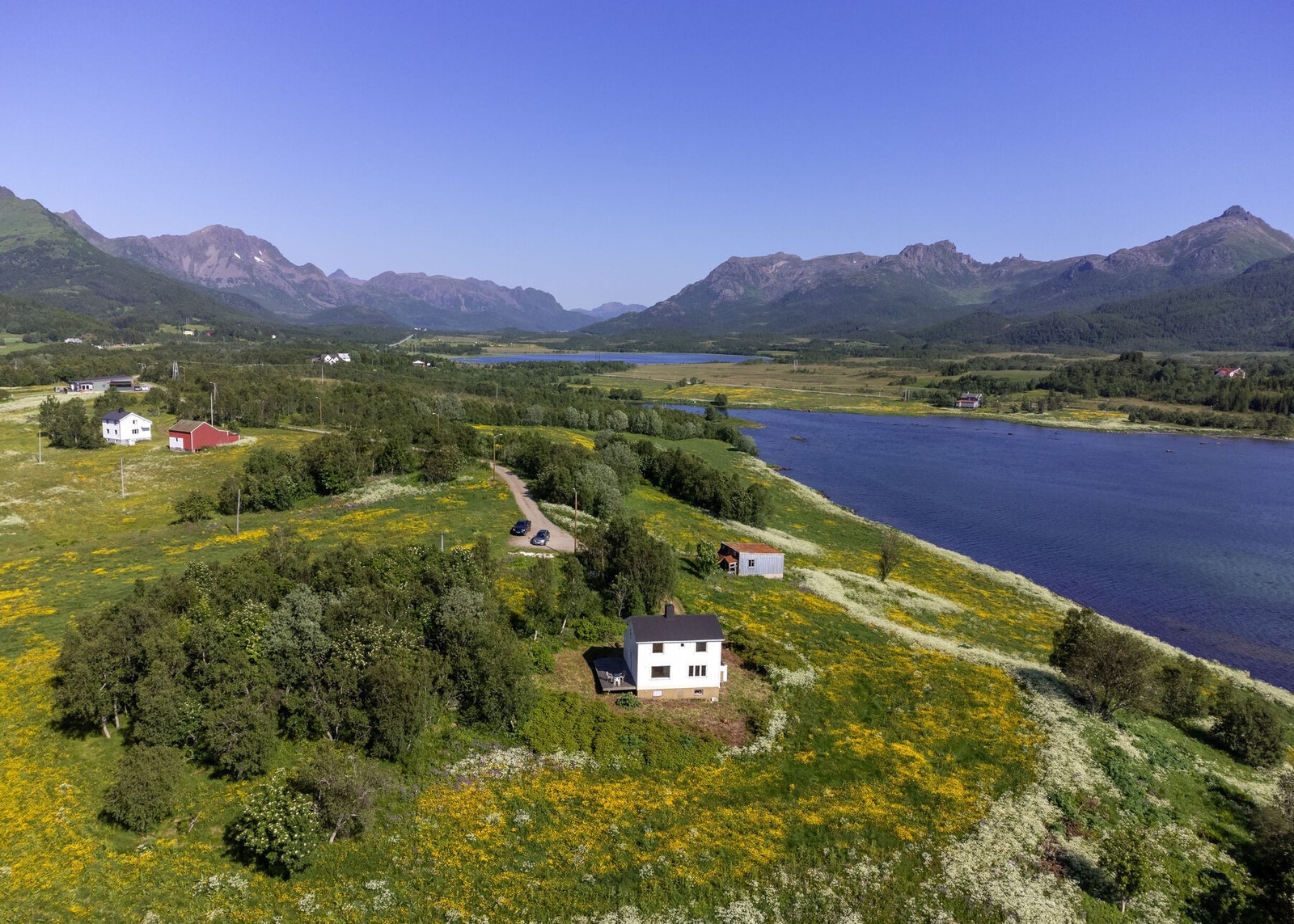 Boligen ligger på en stor tomt og har et tilhørende eldre fjøs/uthus Galleribilde
