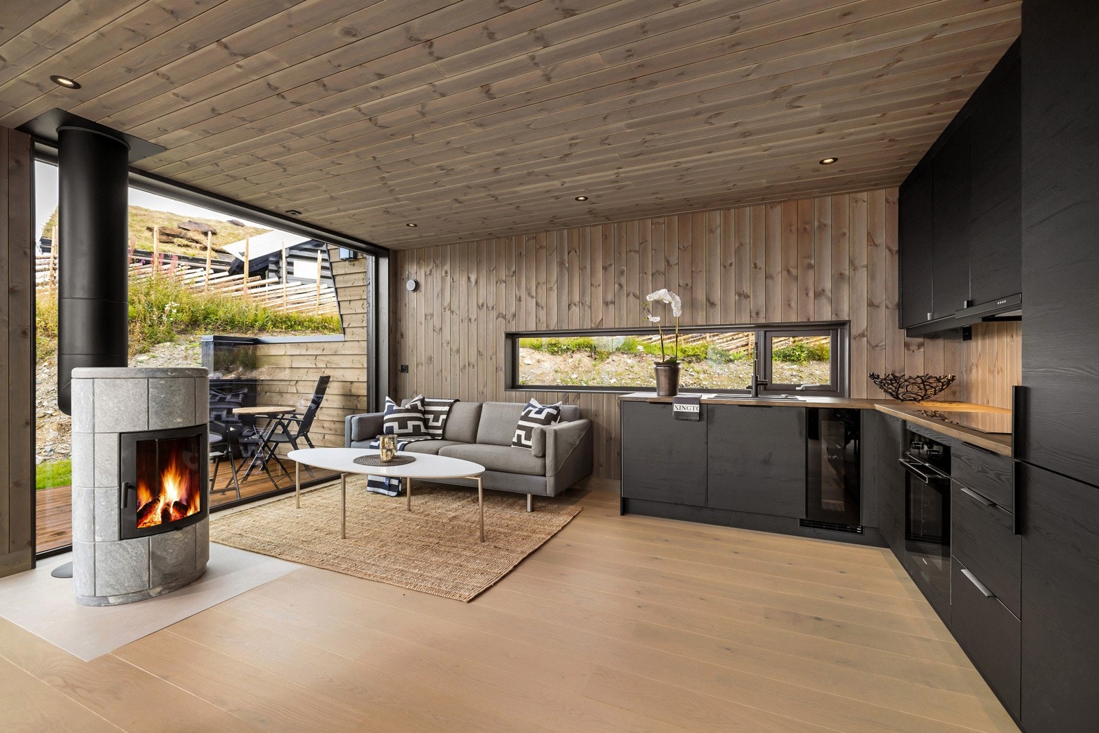 Stuen og kjøkkenet ligger i åpen løsning. I midten av rommet er det en flott klebersteinsovn som gir både hygge og varme til rommet. Galleribilde