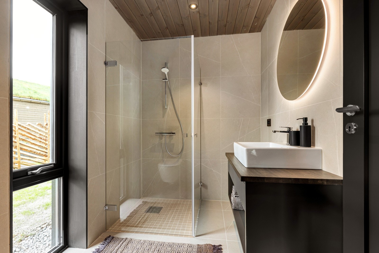 Badet tilknyttet soverommet i 1. etasje er svært lekkert med sandfargede fliser på gulv og vegger. Galleribilde