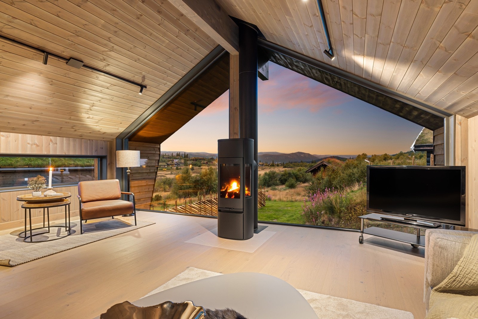 I overetasjen er det en fantastisk stue med panoramavinduer vendt mot fjellene og naturlandskapet rundt. Galleribilde