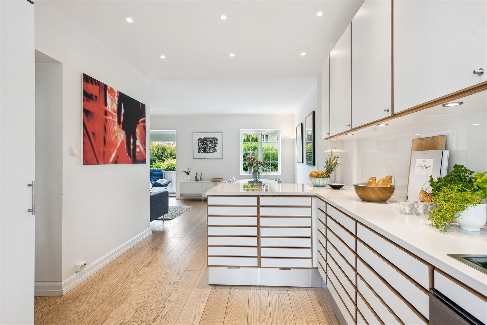 Et lyst og moderne kjøkken i åpen løsning mot stuen. Galleribilde