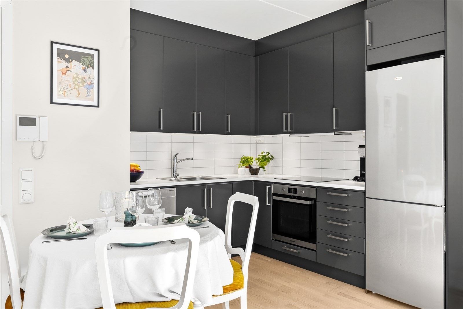 Kjøkkeninnredning fra byggeåret med slette fronter, laminat benkeplate med fliser på bakvegg. Integrert stekeovn, platetopp og kjøleskap følger med. Galleribilde