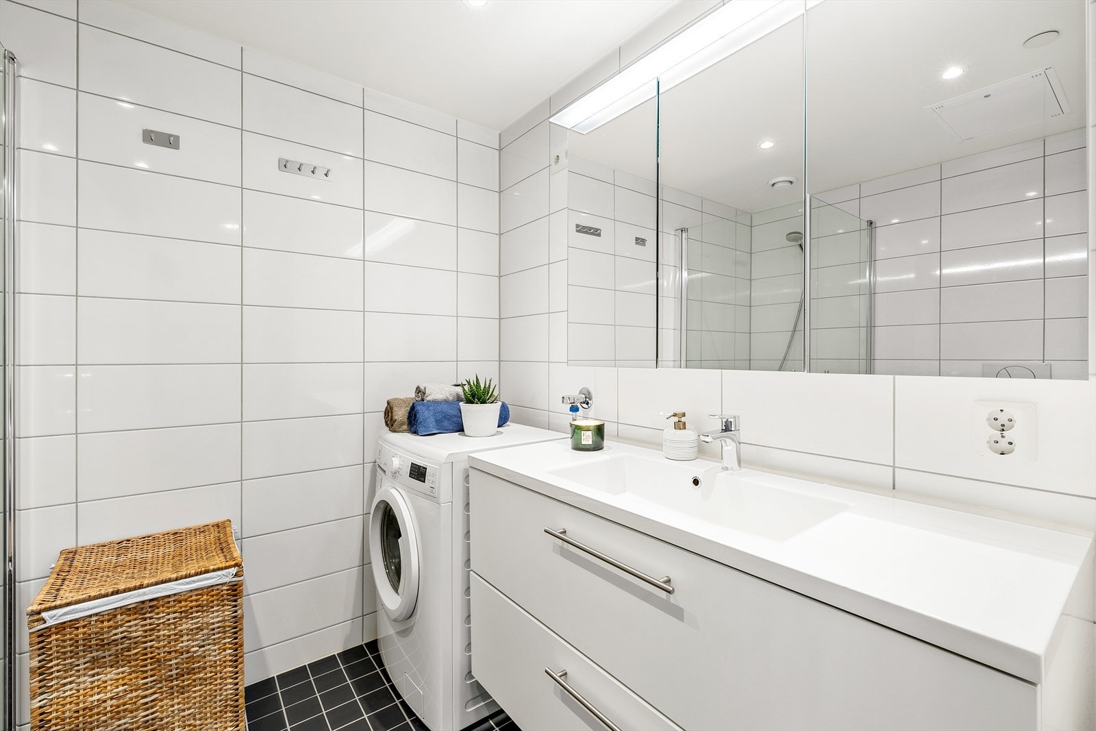 Flislagt baderom med opplegg for vaskemaskin og tørketrommel. Galleribilde