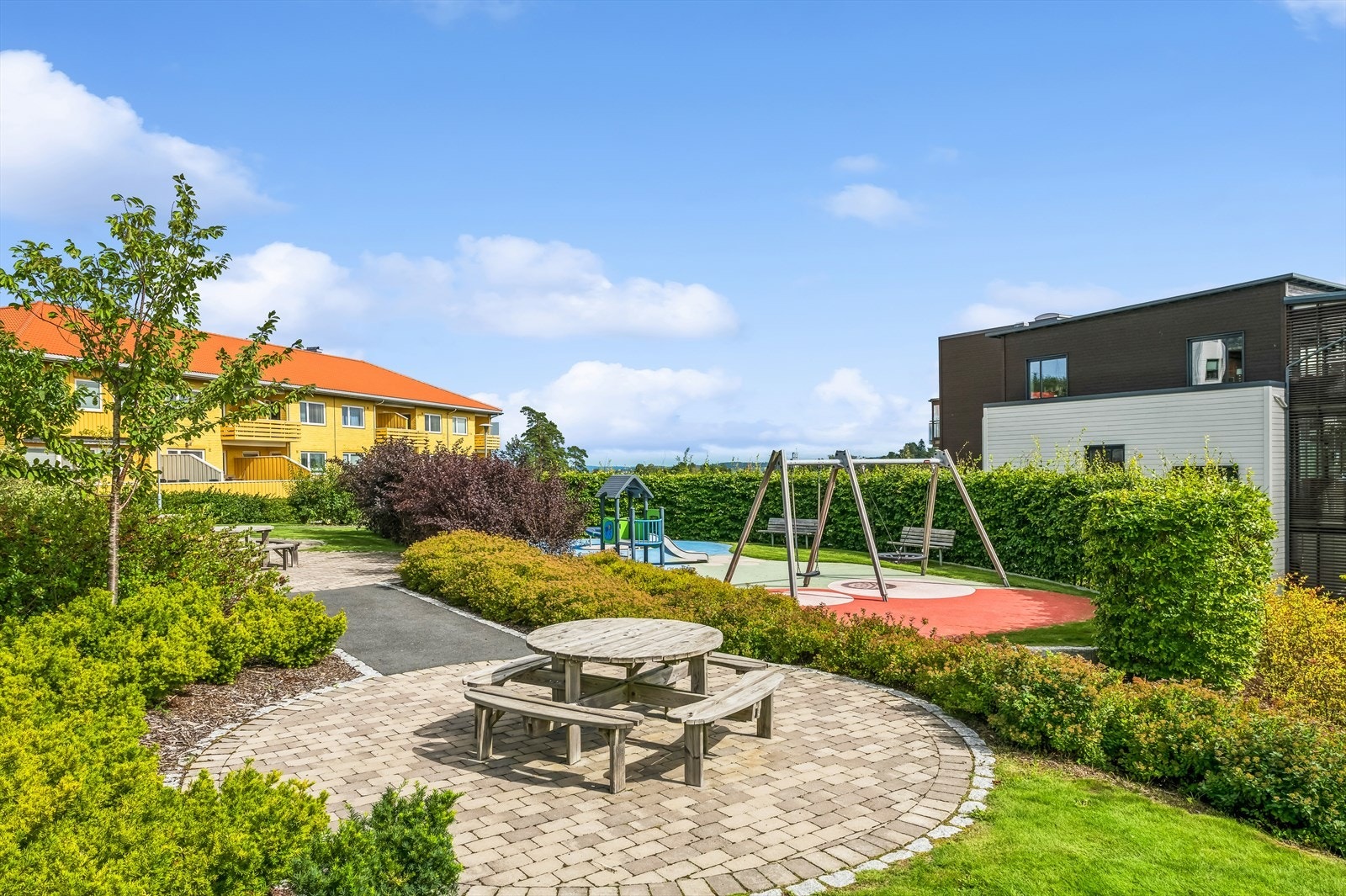 Tomten er flott opparbeidet med asfalterte internveier, diverse beplantning, lekeplass, sittegrupper og prydbusker. Galleribilde