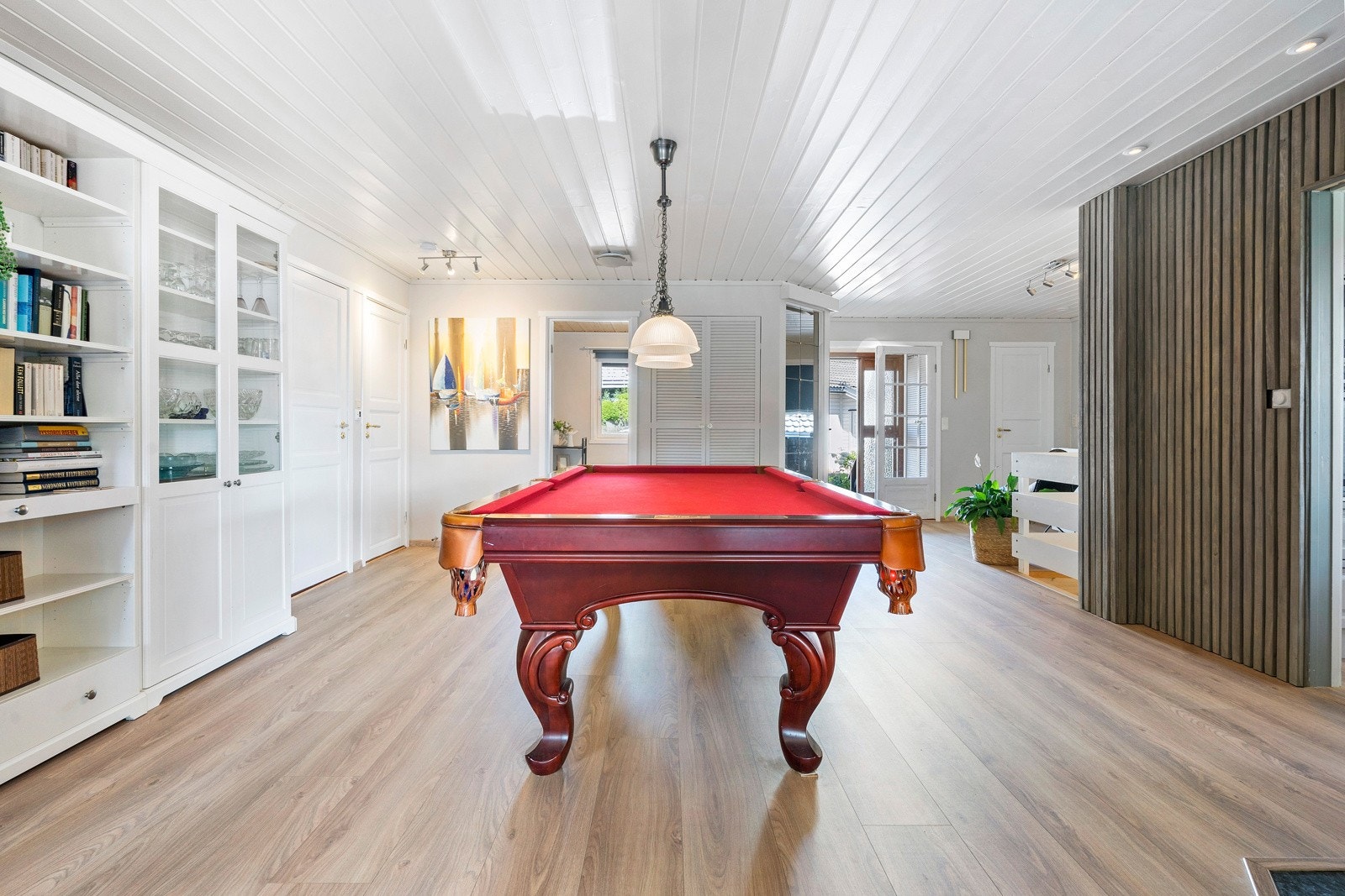 Hallen er i dag innredet med biljardbord som medfølger boligen. Monter plassbygget garderobe i bakkant, samt i vindfanget, som gjør det enkelt å rydde sko og jakker ut av syne Galleribilde