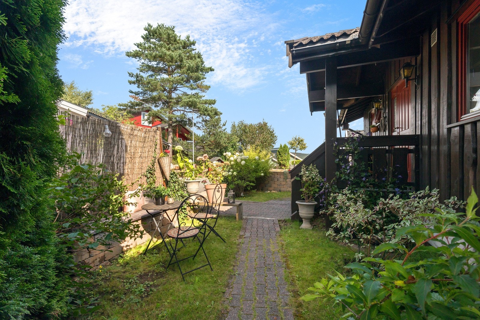 Koselig inngangsparti med ny mur, grøntareal og diverse beplantning Galleribilde
