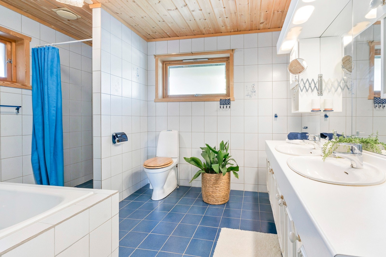 Romslig bad i hovedetasjen med adkomst fra hallen og fra hovedsoverommet. Baderommet er flislagt med gulvvarme og innredet med innebygd badekar med veggmontert armatur, dusjnisje, gulvstående toalett, og servantseksjon med skap og to servanter Galleribilde