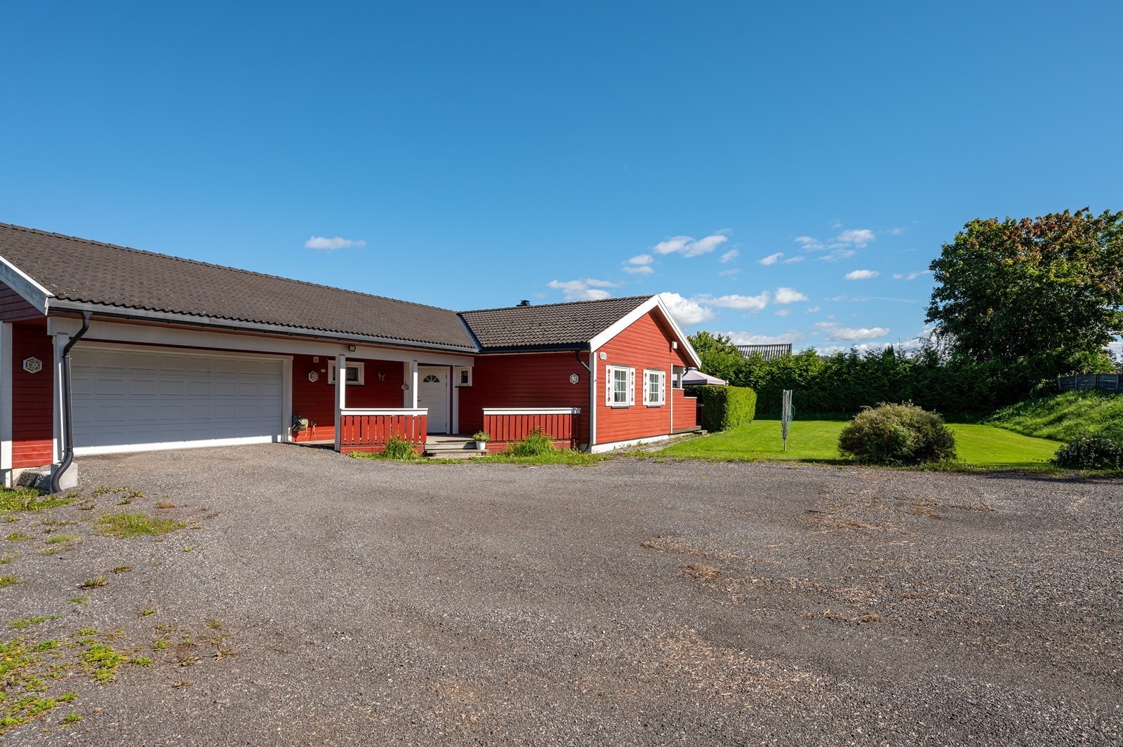 Parkering kan gjøres på gårdsplassen eller i den integrerte garasjen - som har dør inn til boligen via en bod. Galleribilde