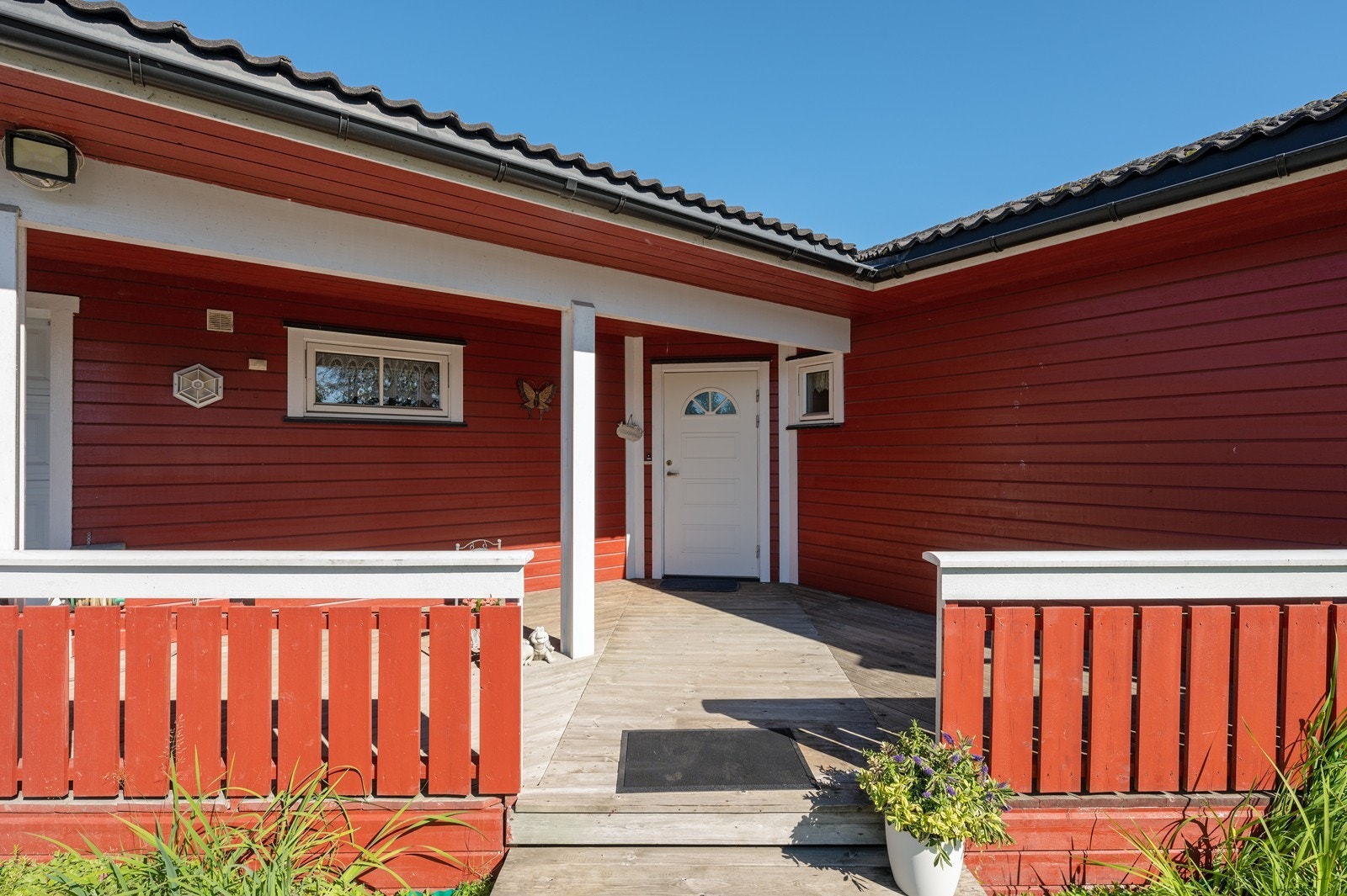 Boligen har et romslig og delvis overbygd inngangsparti - med plass til utemøblement. Galleribilde