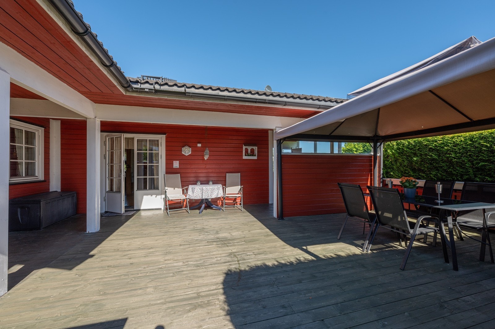 Fra boligen er det utgang til en stor, delvis overbygd terrasse med en tilliggende hagestue. Galleribilde