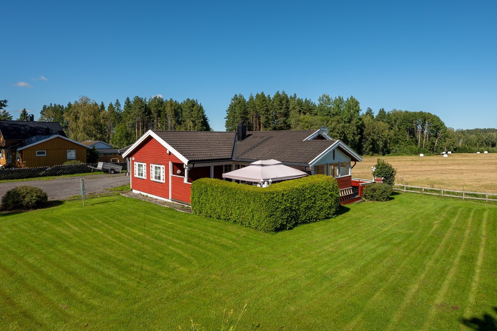 En frodig, vintergrønn tujahekk sørger for skydd for vær, vind og innsyn på terrassen. Galleribilde