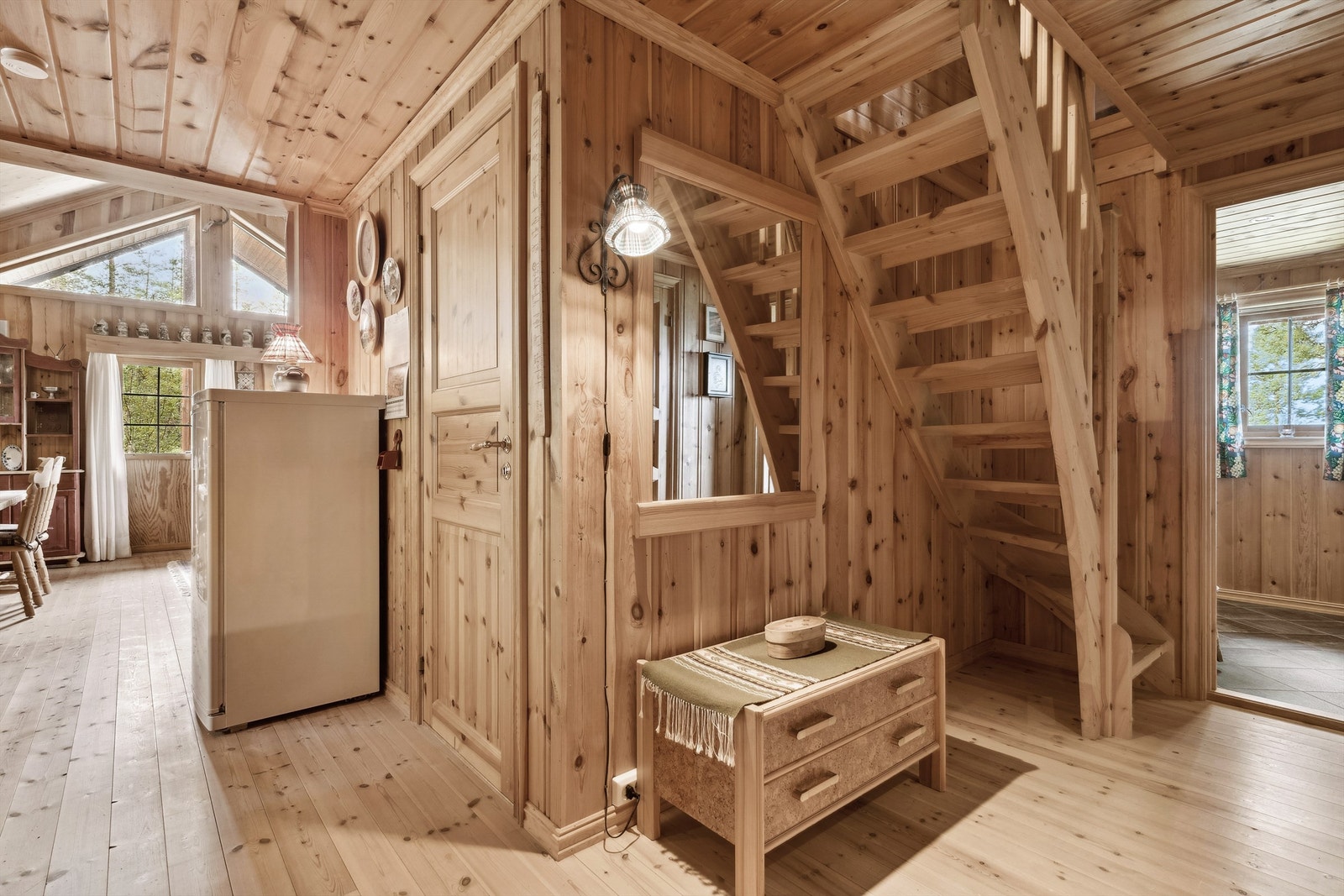 Videre inn i gangen er det tregulv, panel på veggene og i himling. Her er det trapp opp til 2. etasje og åpen løsning inn til stue/kjøkken. Galleribilde