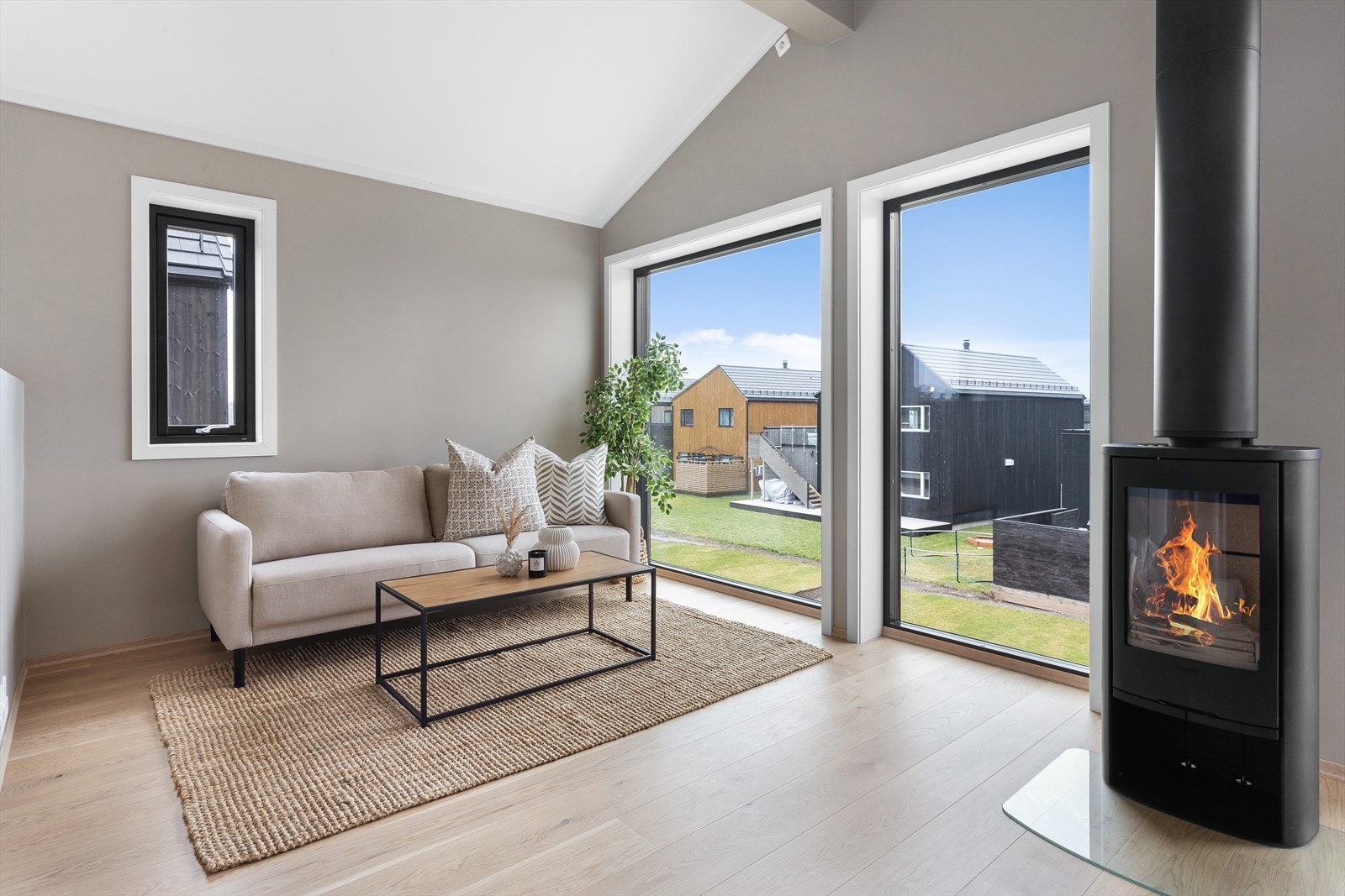 Stue med panoramavinduer og peisovn Galleribilde
