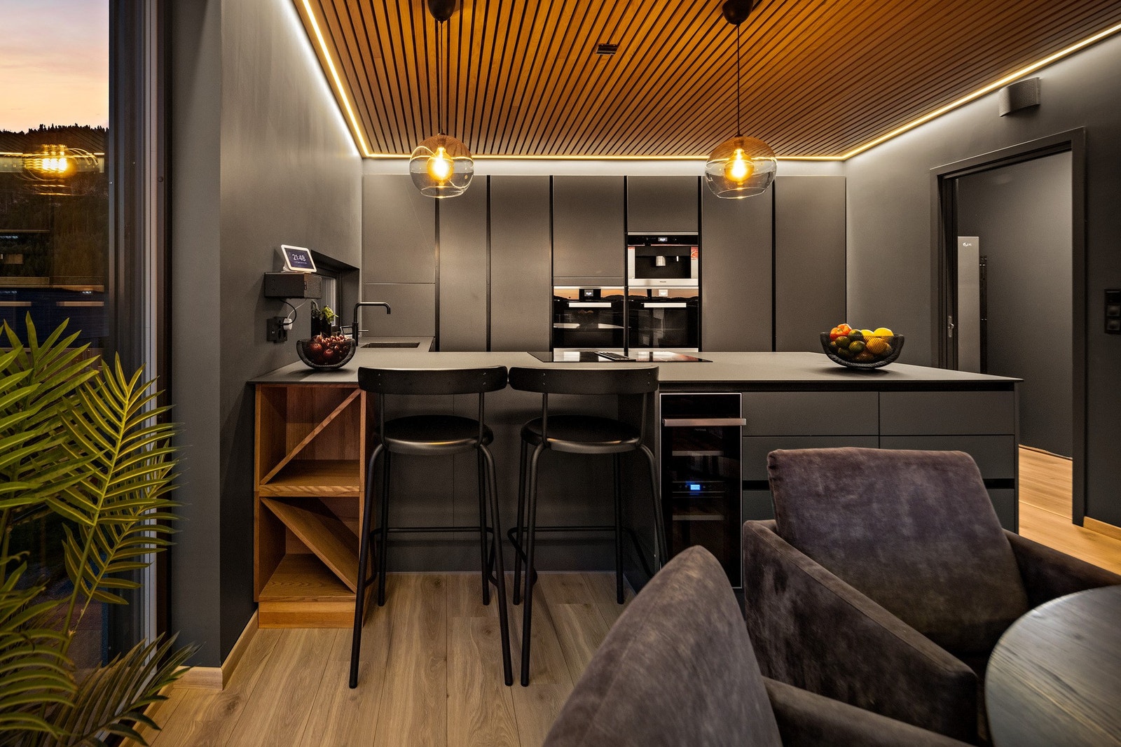 Praktisk kjøkkenøy med barløsning og integrert vinskap. Til høyre ser du dør inn til egen matbod med bl.a kjøleskap Galleribilde