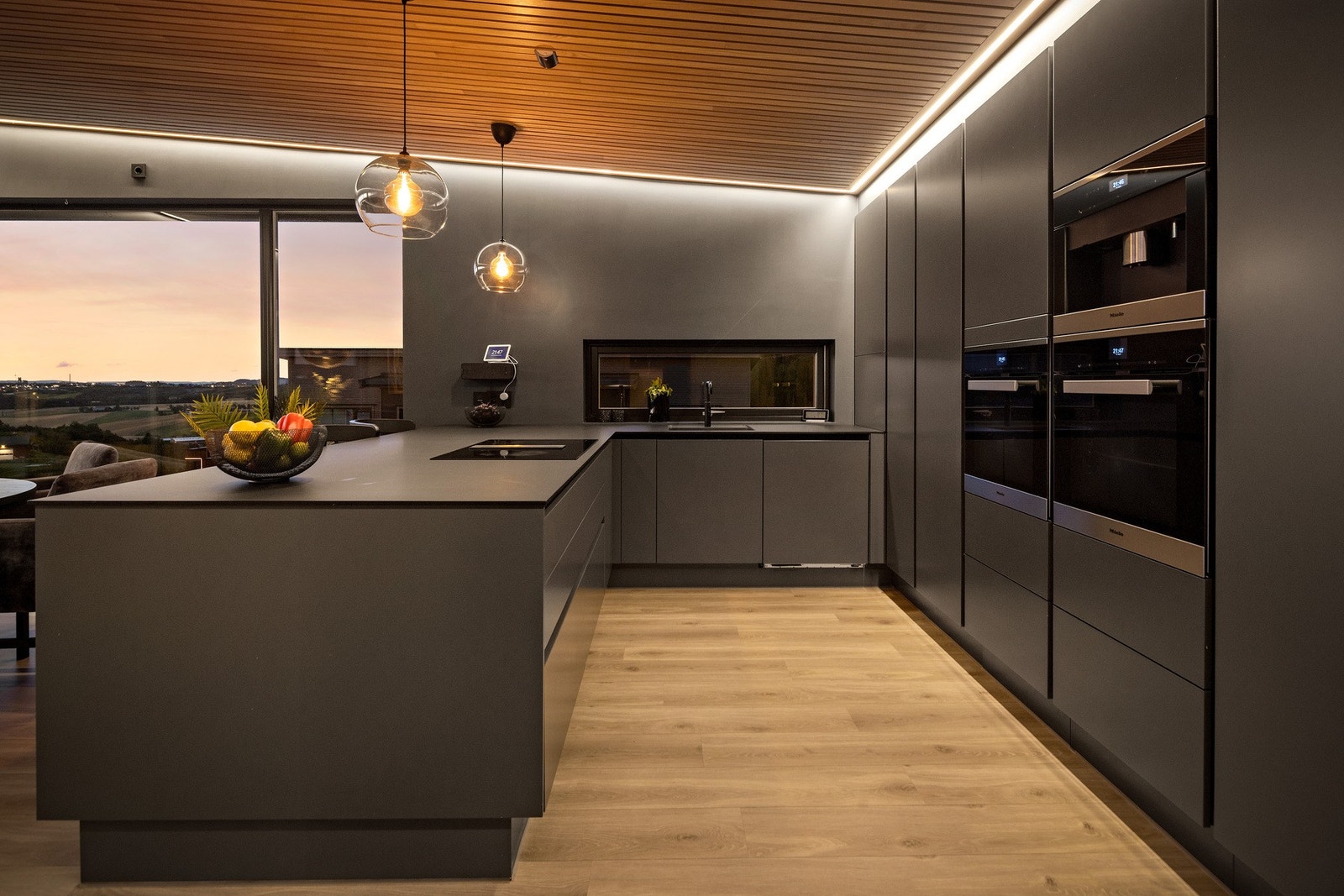 Lekkert kjøkken fra HTH med integrerte hvitevarer fra Miele med bl.a kaffemaskin, to stekovner og platetopp med integrert ventilator Galleribilde