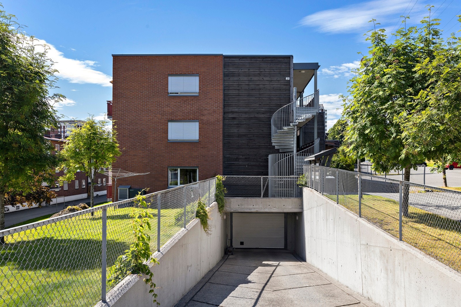 Garasjeplass medfølger. Bildet viser innkjøringen til garasjen. Heis ned til garasjeanlegg like ved inngangsdøren. Galleribilde