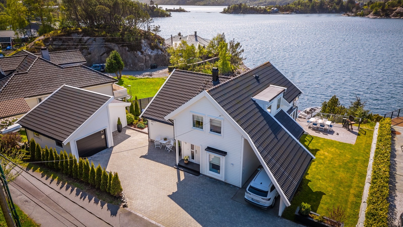 Eiendommen er meget pent opparbeidet med blant annet beleggningsstein i innkjørsel, plen, bed og terrasse, Galleribilde