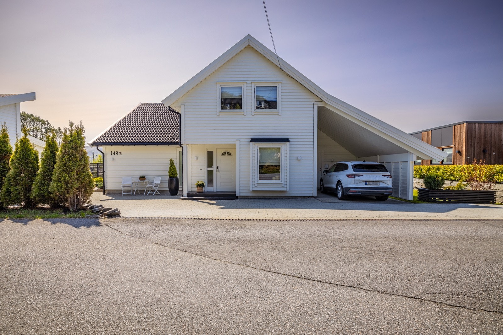Eiendommen kan by på både carport med elbillader og en romslig garasje. Galleribilde