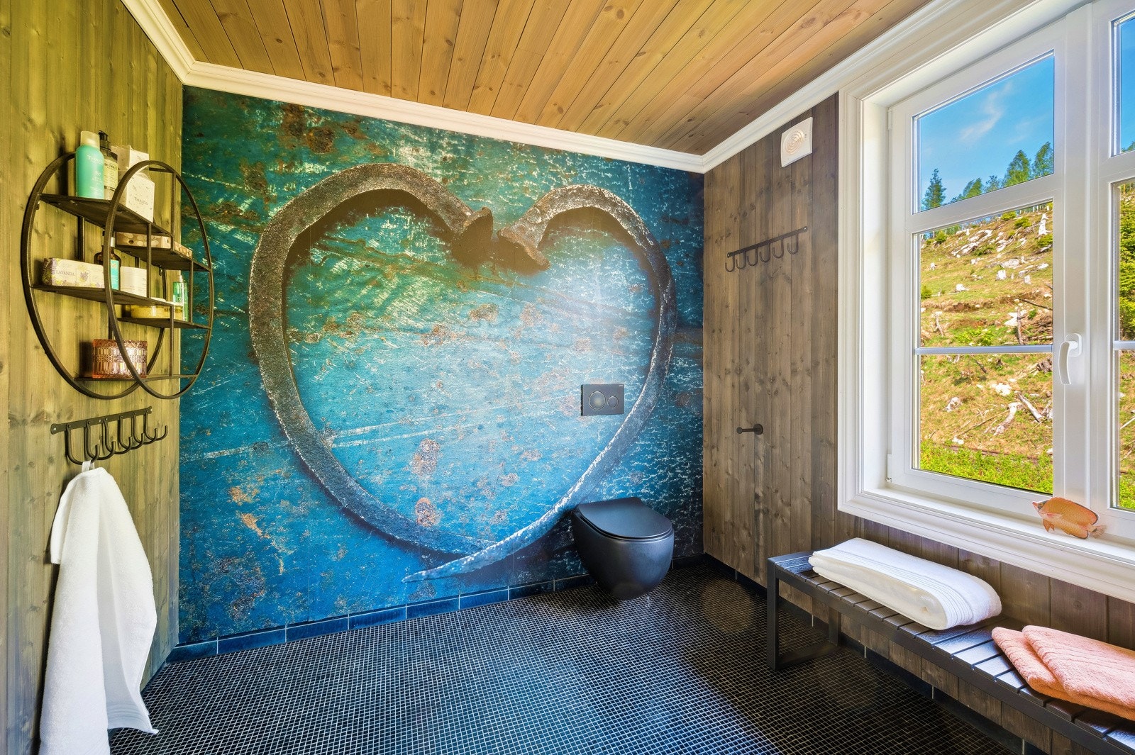 Luksuriøst, stort bad med moderne interiør. Badet er 9 kvm. og har steamdusj og matt, svart baderomsinnredning. Nydelige blåsvarte mosaikkfliser på gulvet. Dekortapet på én vegg. Galleribilde
