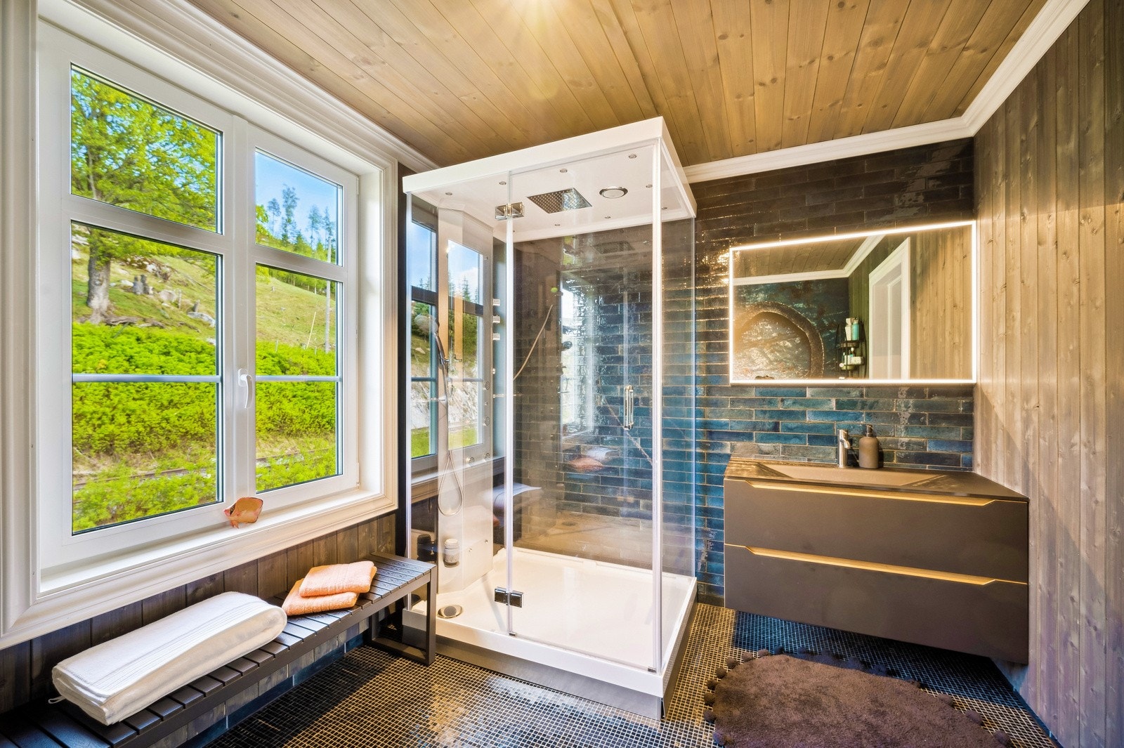 Badet har en matt, svart innredning, og har vindu mot øst og vekk fra inntunet Galleribilde