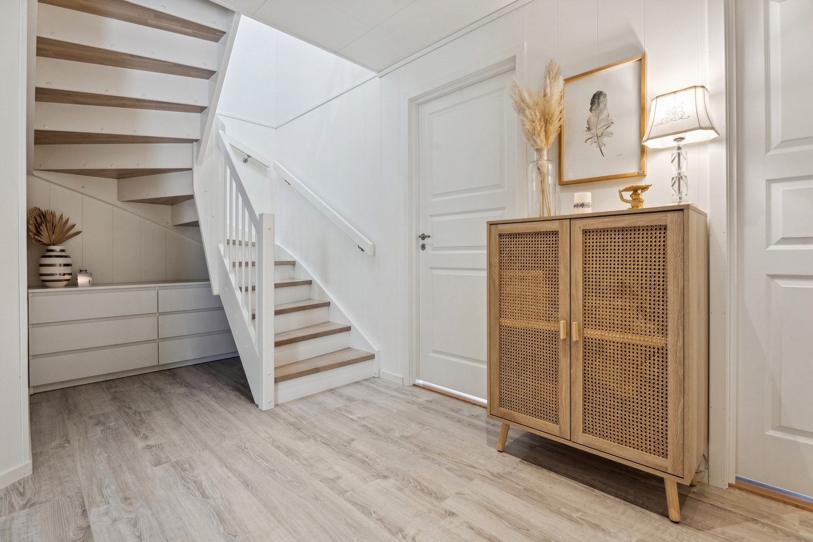 Romslig hall med trapp opp til hovedetasjen. Galleribilde