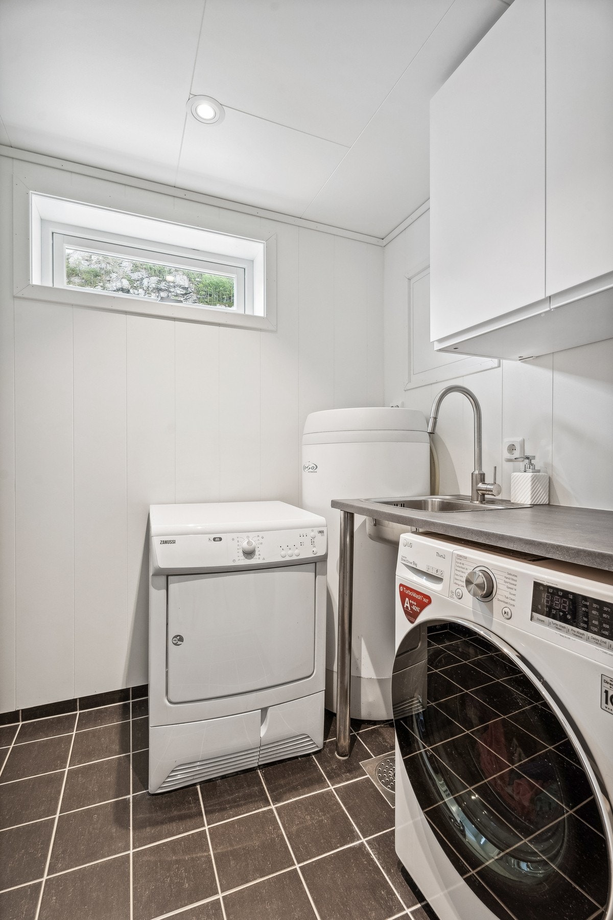 Praktisk vaskerom innredet med arbeidsbenk og utslagsvask. Galleribilde