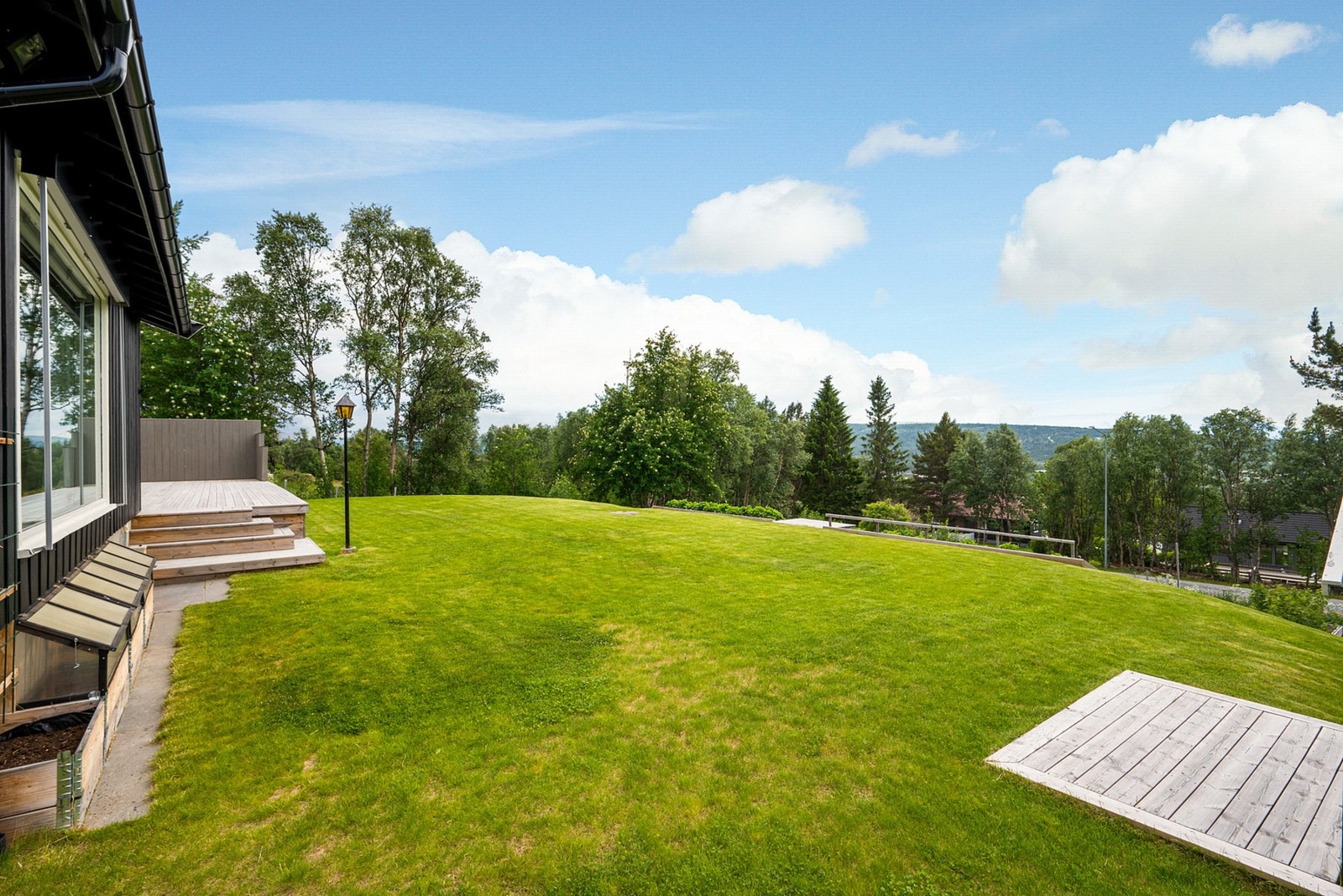 Den består av pent opparbeidet plen som stekker seg rundt hele boligen. Galleribilde
