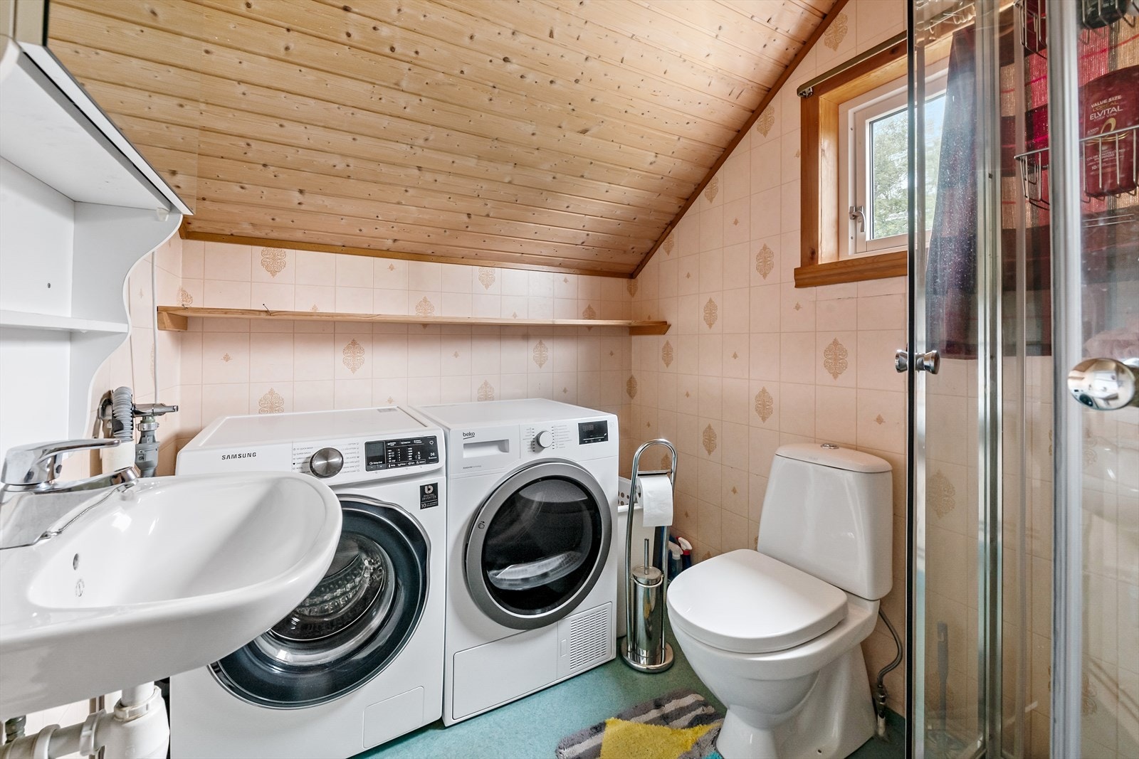 Badet i 2. etasje med våtromsbelegg på gulv og våtromstapet på vegger. Innredet med toalett, vask og dusjkabinett. Det er opplegg for vaskemaskin. Galleribilde