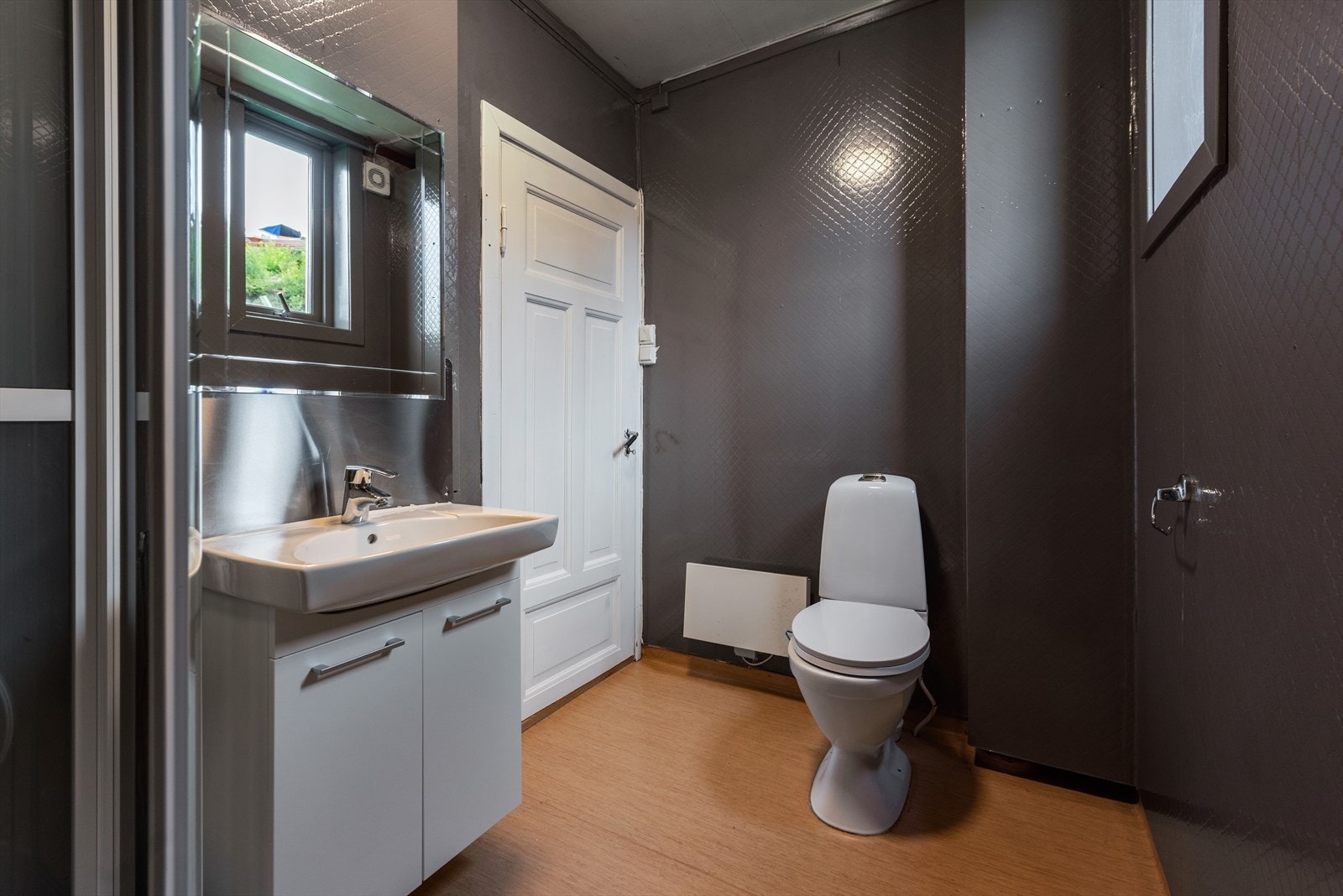 Baderom i 1. etasje med dusjkabinett, servant og toalett. Nyere innredning. Galleribilde