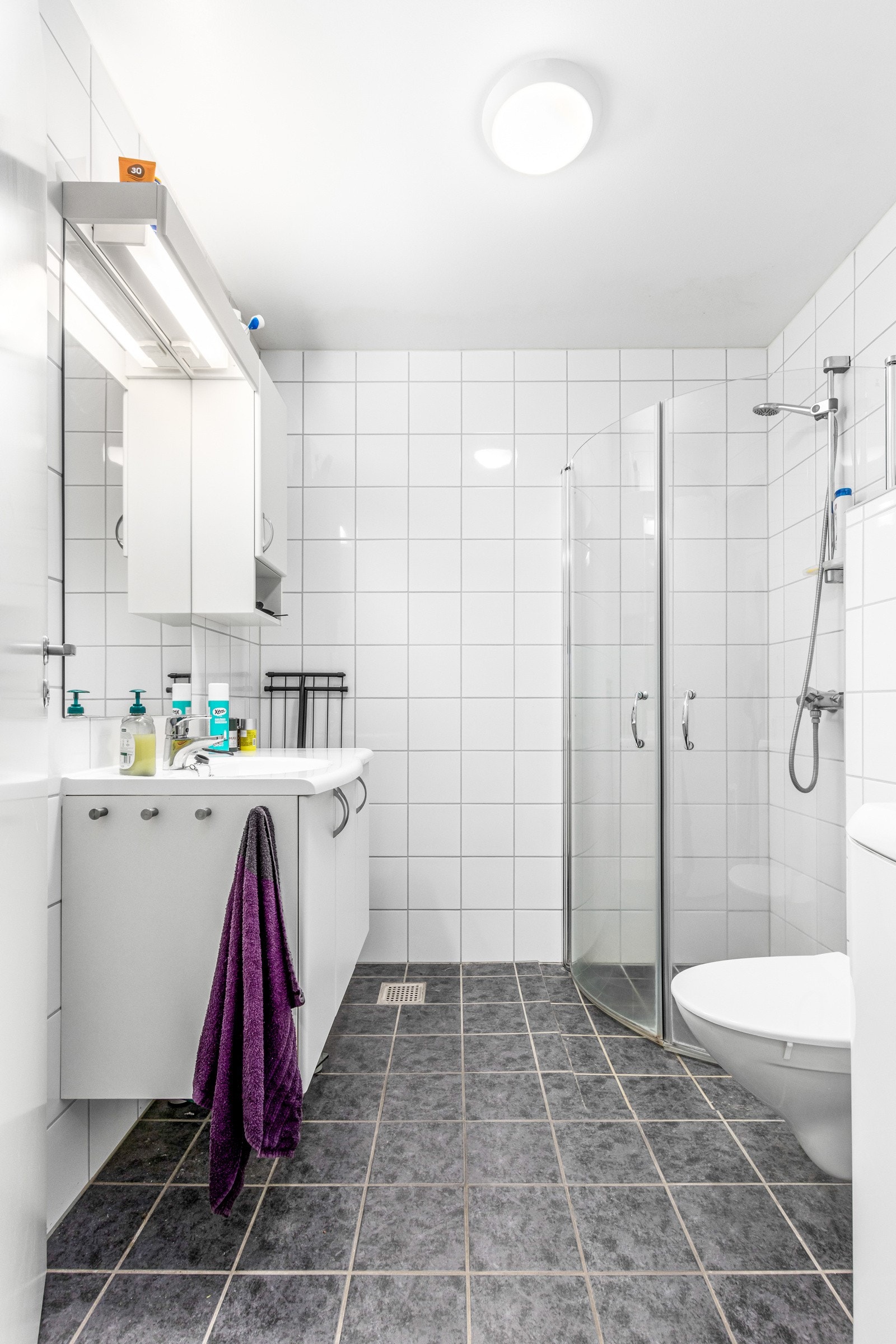 Flislagt bad med opplegg for vaskemaskin. Galleribilde