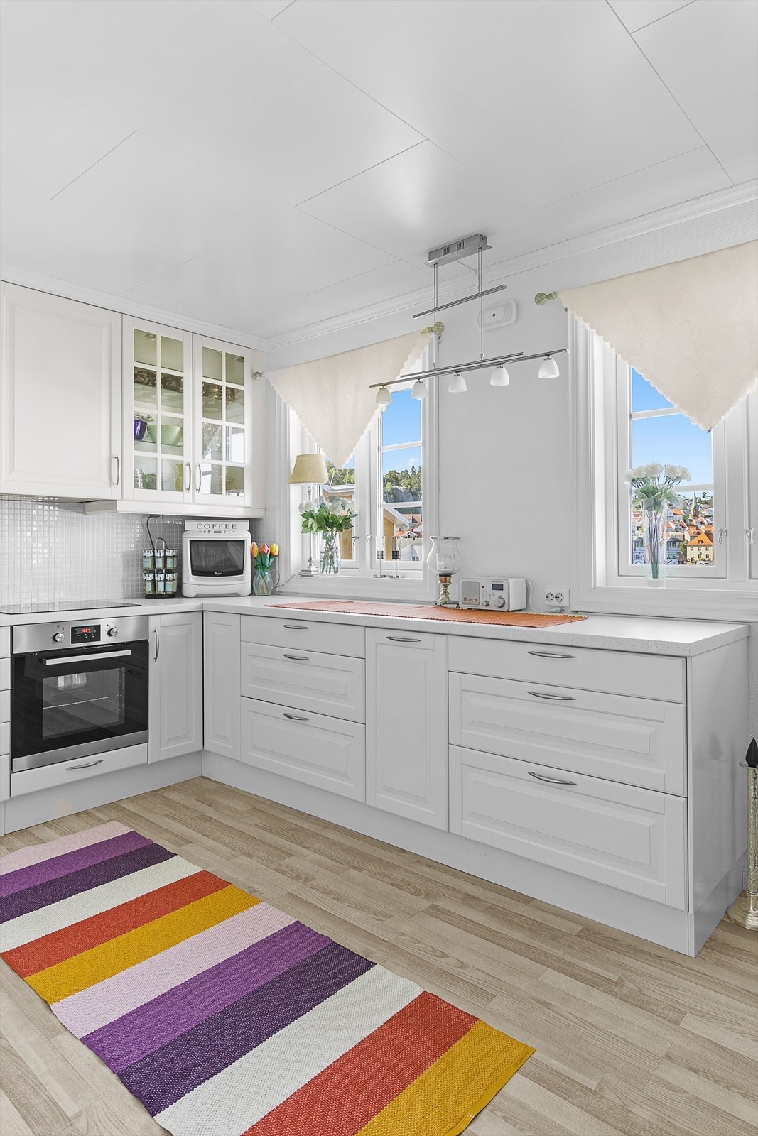 Nyere kjøkken med innredning fra Ikea. Laminat benkeplate og flis mellom benk og overskap. Integrert oppvaskmaskin, kjøleskap, koketopp og stekeovn. Galleribilde