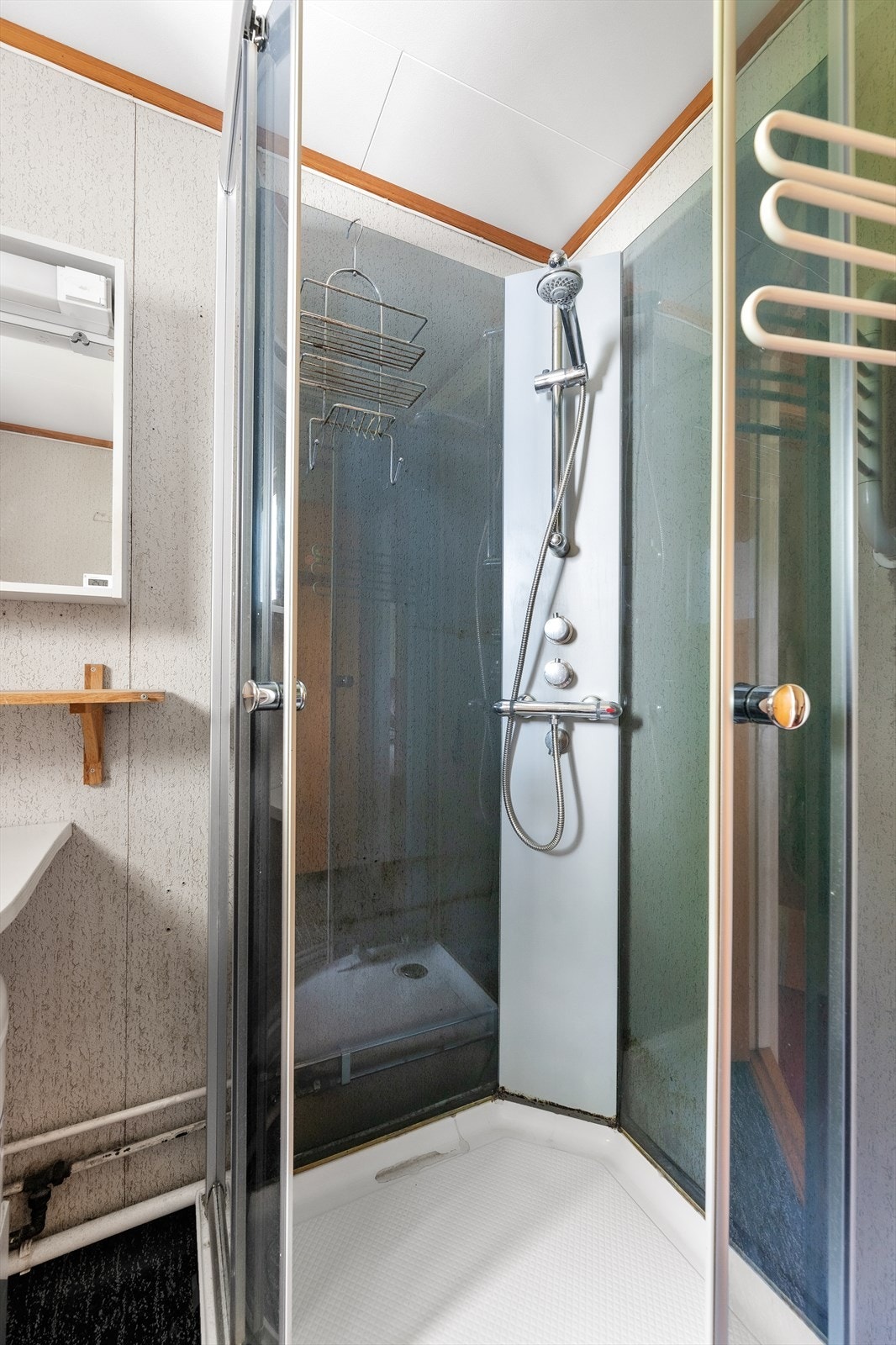 Badet er utstyrt med dusjkabinett, gulvstående wc og servantinnredning med underskap. Galleribilde