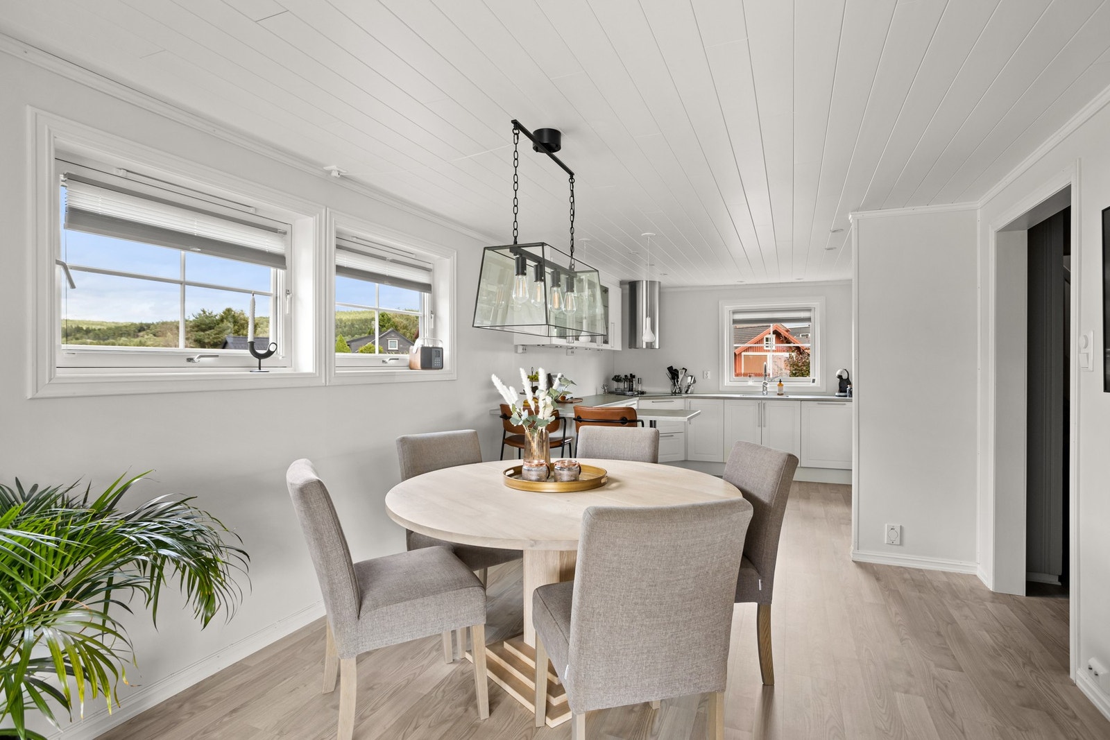 Spisebordet er plassert i den naturlige overgangen mellom stue og kjøkken Galleribilde