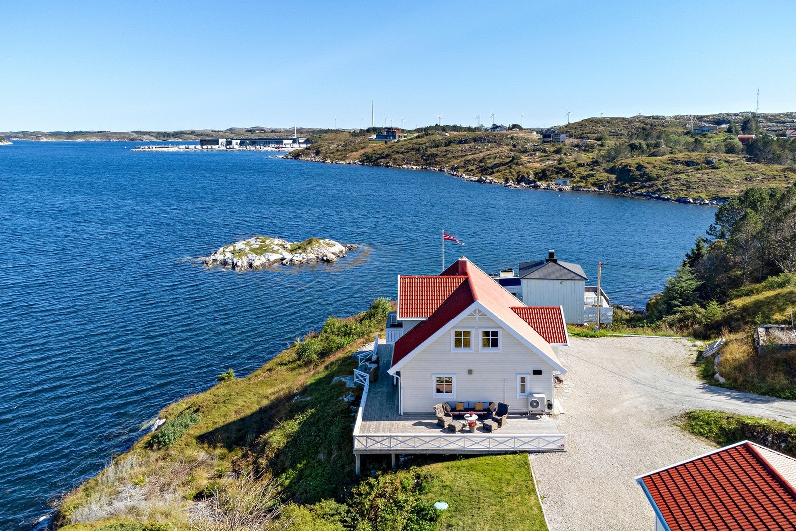 Strålende solforhold med terrasse som strekker seg rundt store deler av huset Galleribilde