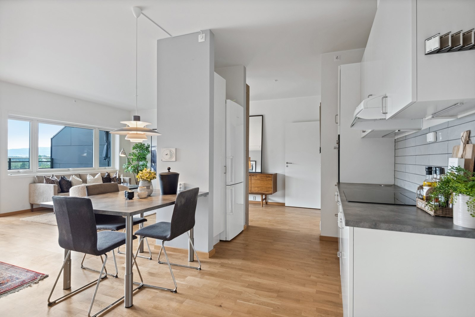 Kjøkkeninnredningen har lyse, laminerte skrog og glatte fronter med laminert benkeplate. Under overskapene er det belysning og pent flislagt. Galleribilde