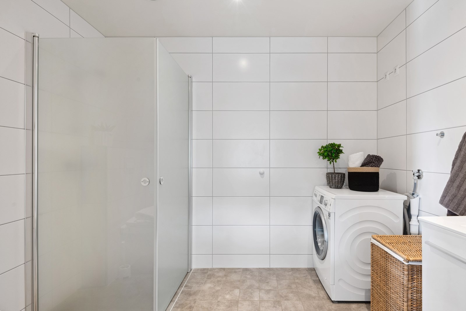 Baderommet i tilknytning til soverommet kombineres også fint som vaskerom med opplegg til vaskemaskin. Her er det godt å stå opp om morgenen med varmekabler i gulvet og downlights i himling. Galleribilde