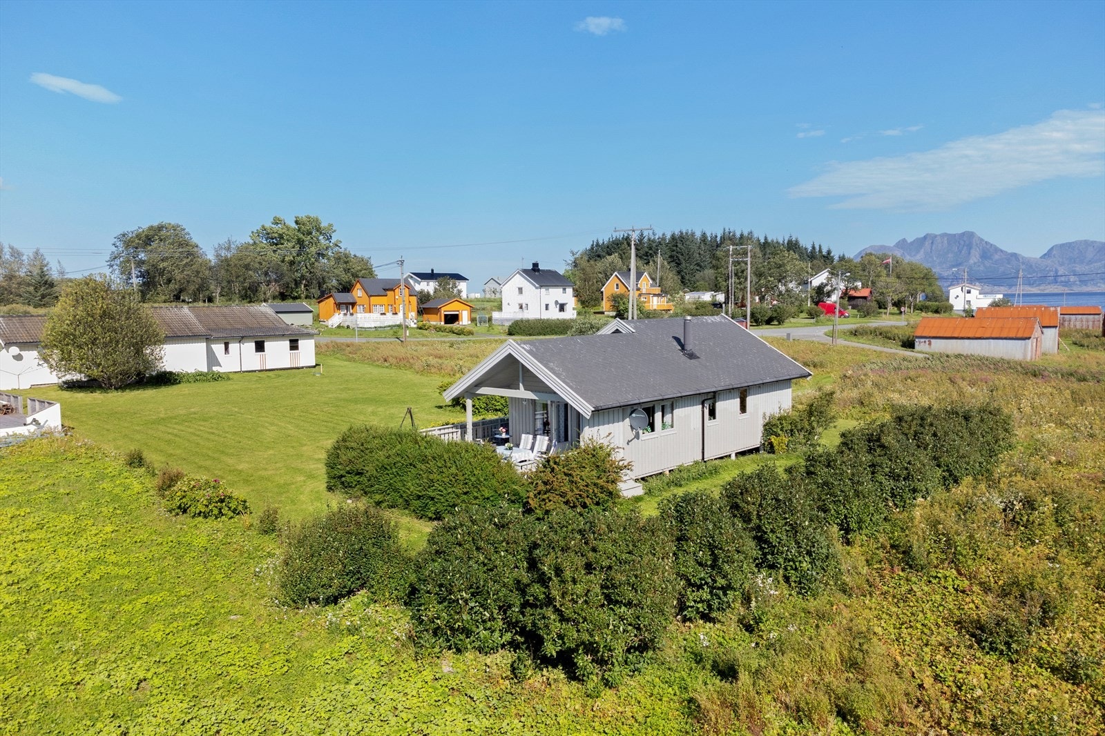 Store deler av tomten er opparbeidet med plen og buske. Det er også klipt gangvei fra bilveien og inn til tomten. Galleribilde