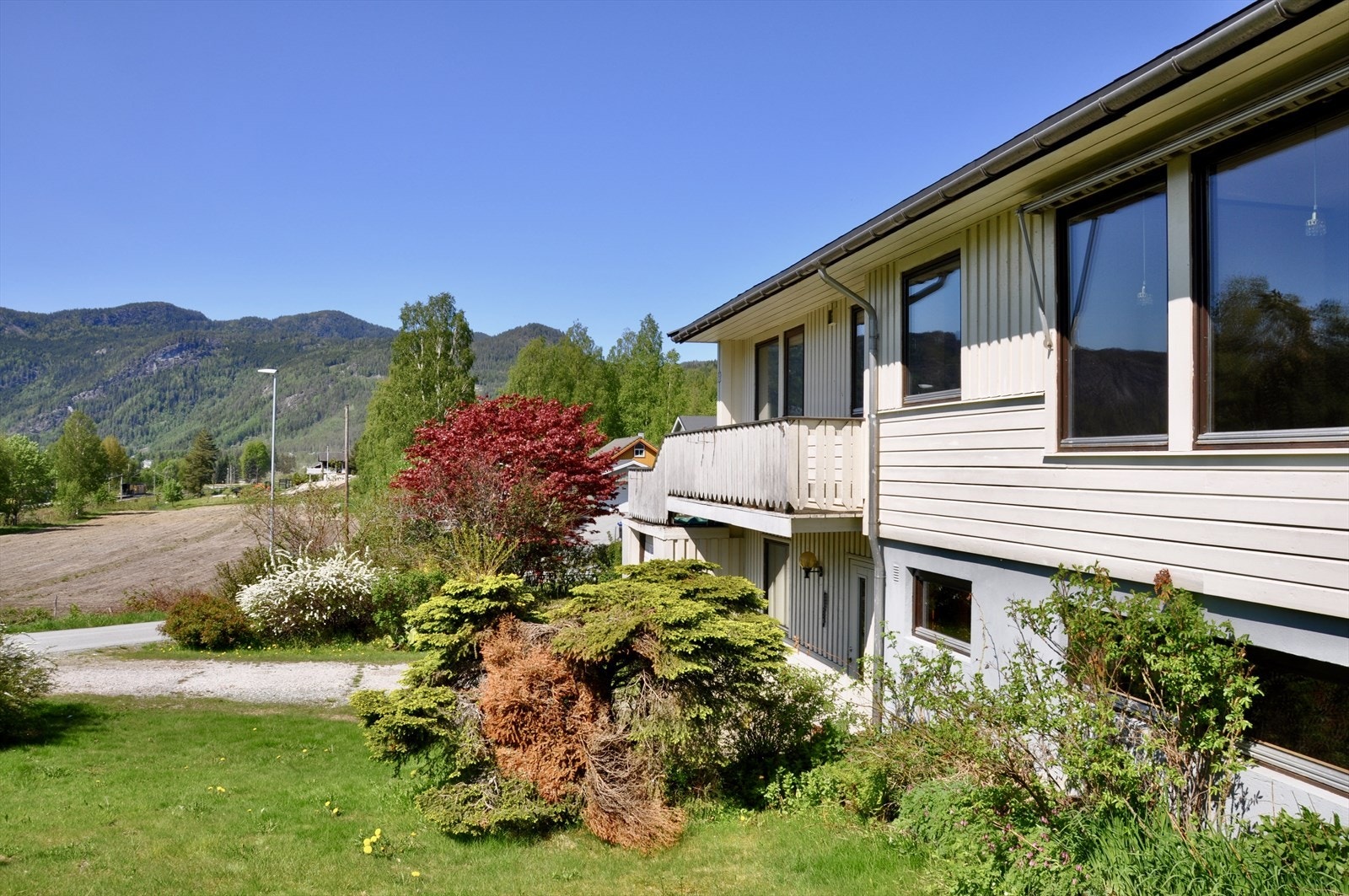 Boligen har en frodig hage bestående av en rekke prydbusker, planter og frukttrær. Galleribilde