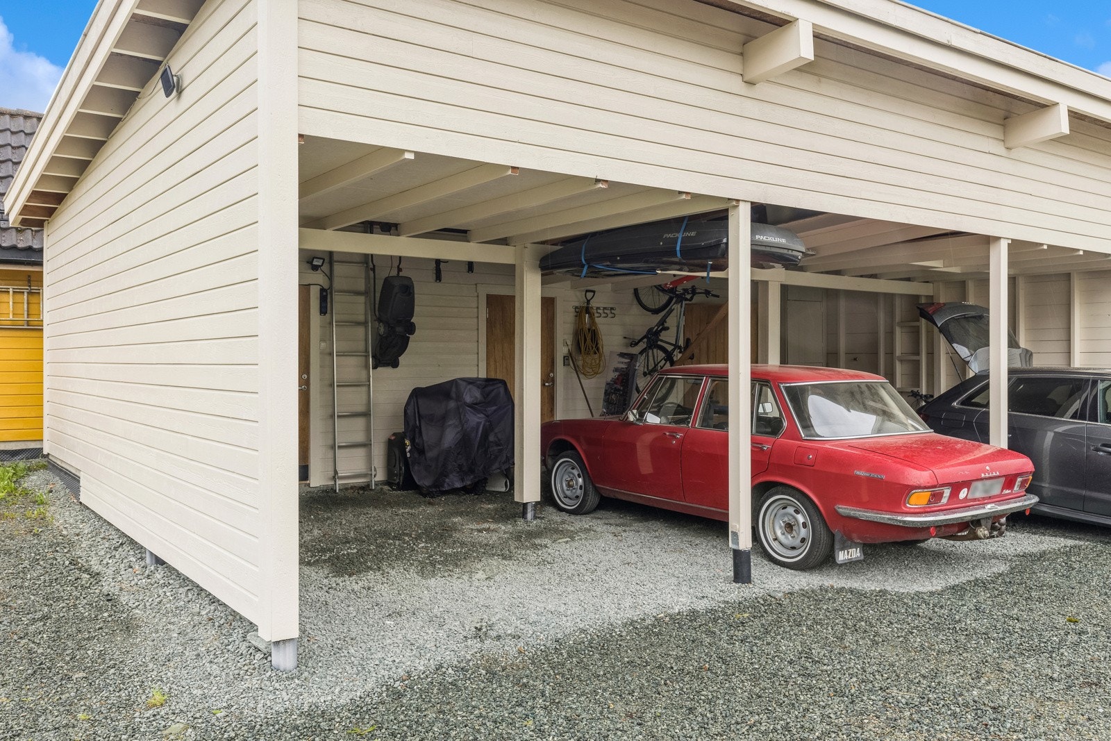 Det følger med en carport i rekke og en utvendig bod. Boden er isolert og har oppvarming. I tillegg finnes det flere biloppstillingsplasser på felles tomt. Galleribilde