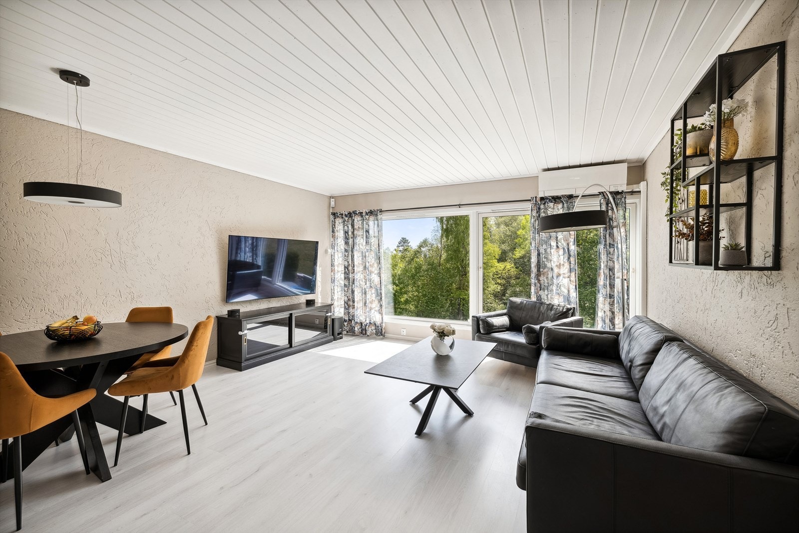 Den gjennomgående løsningen og de heldekkende vinduene gir stuen en lys og luftig atmosfære Galleribilde