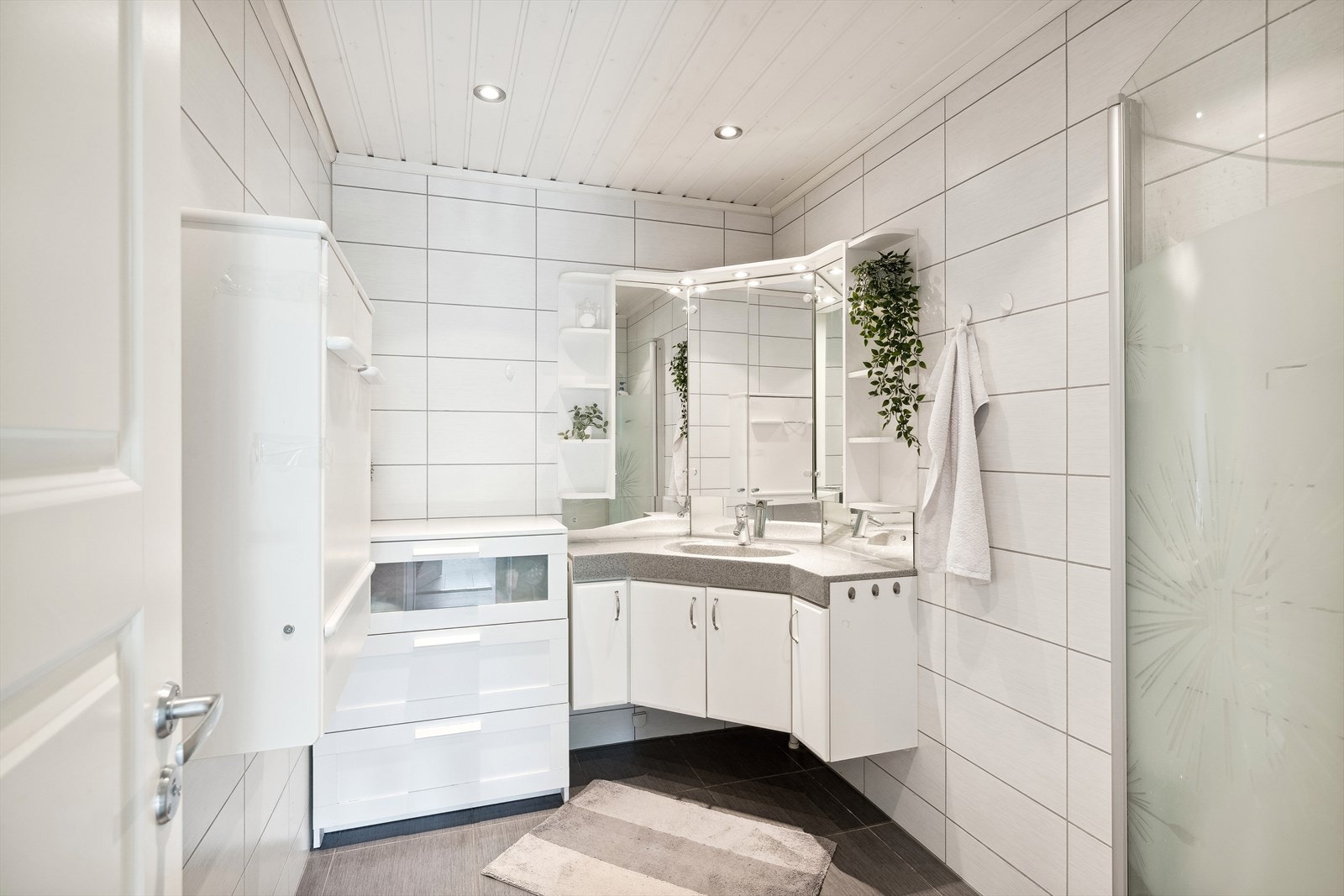 Pent flislagt bad fra 2008 med varmekabler i gulvet og downlights i himlingen. Badet er utstyrt med dusjnisje og servantinnredning med under- og overskap Galleribilde