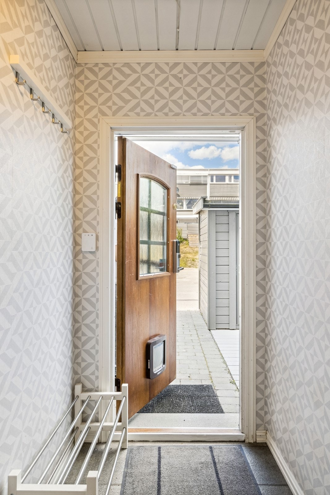 Innenfor døren trer du inn i en flislagt entré med plass til skoskap og oppheng Galleribilde