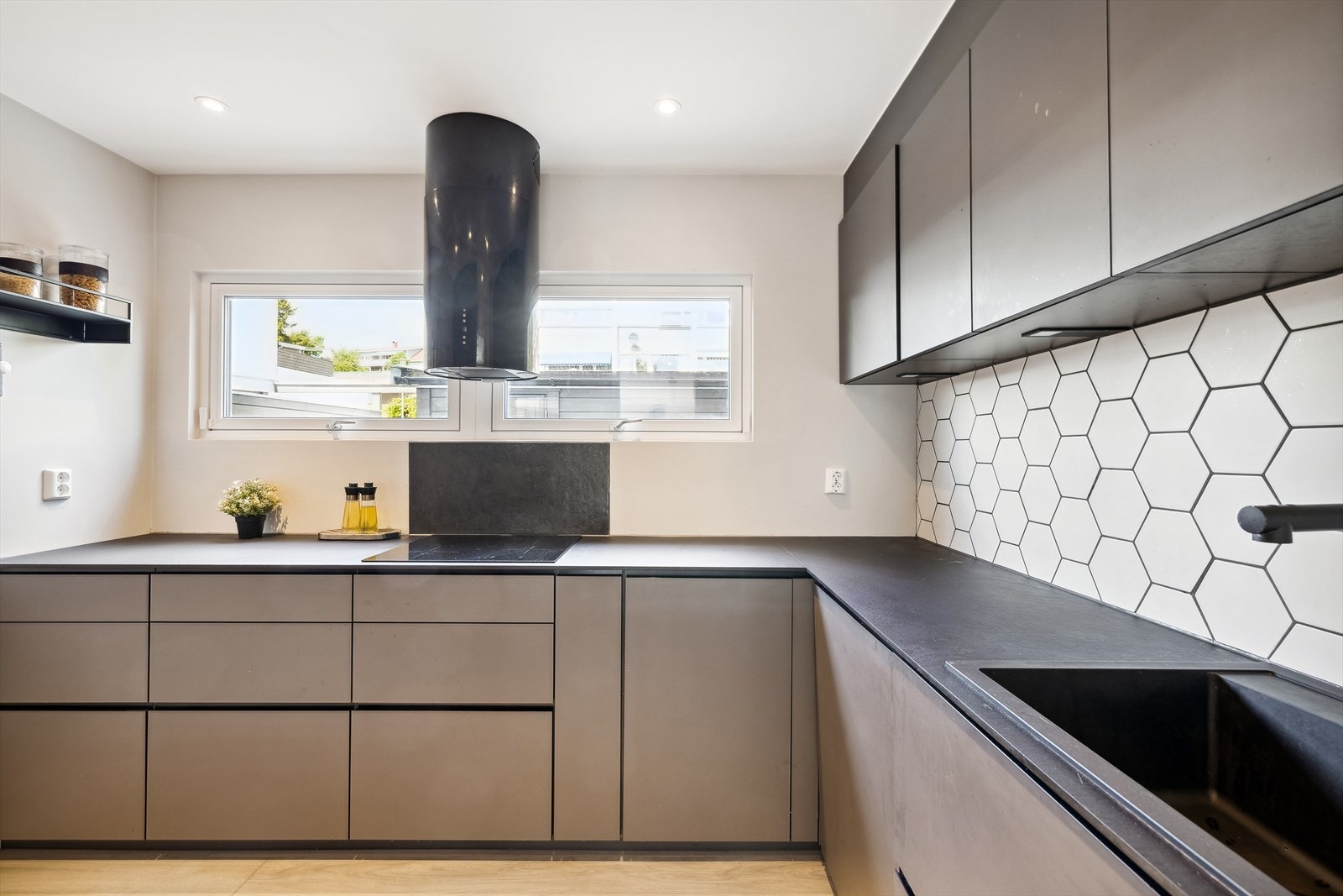 Innredningen har slette fronter og laminerte benkeplater, og vakre heksagon-fliser pryder og beskytter bakveggen Galleribilde