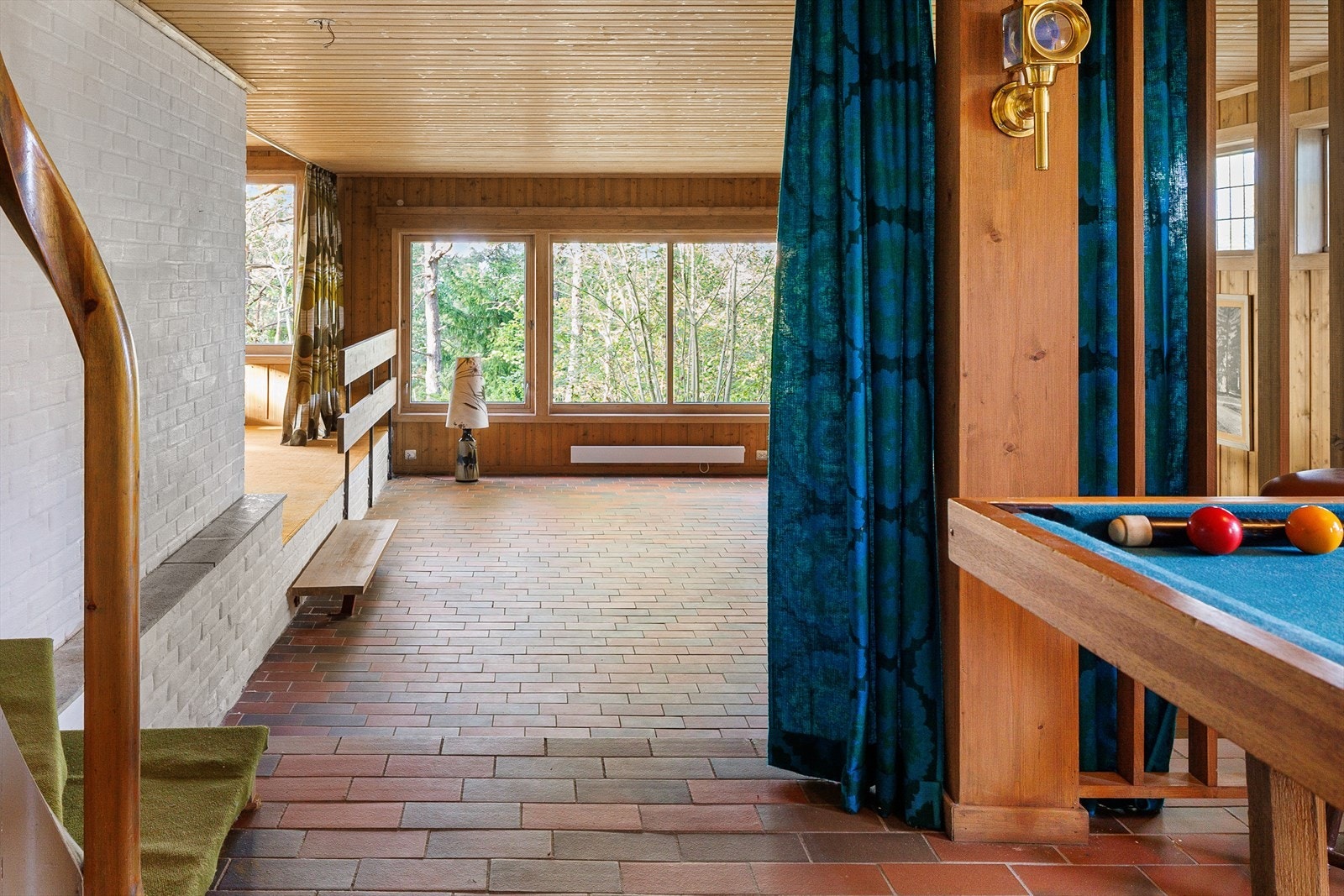 Utenfor de store vinduene danner skogen en selvlysende grønn vegg. Galleribilde