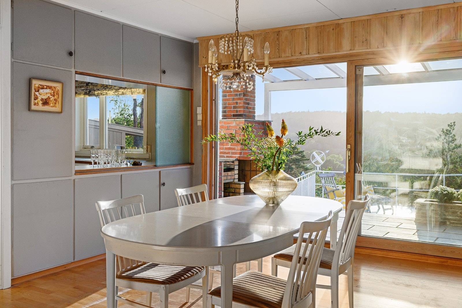 Spisestuen har et serveringsvindu inn til kjøkkenet, og som et ekko av dette, har spisestuen et vindu videre ned til peisestuen. Galleribilde