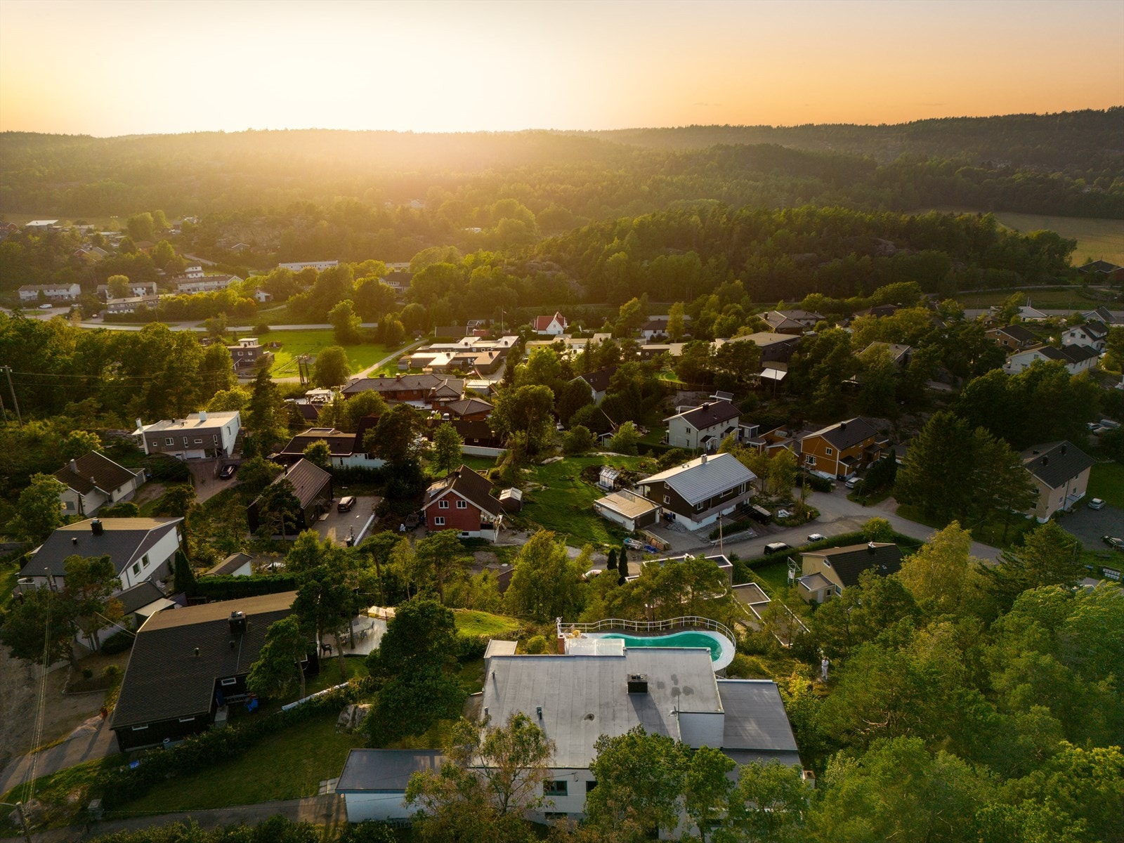 Du kjører opp i høyden, boligene ligger spredt med naturtomter, og for enden av veien ligger en liten samling hus - stille og skjermet. Men likevel sentrumsnært. Galleribilde